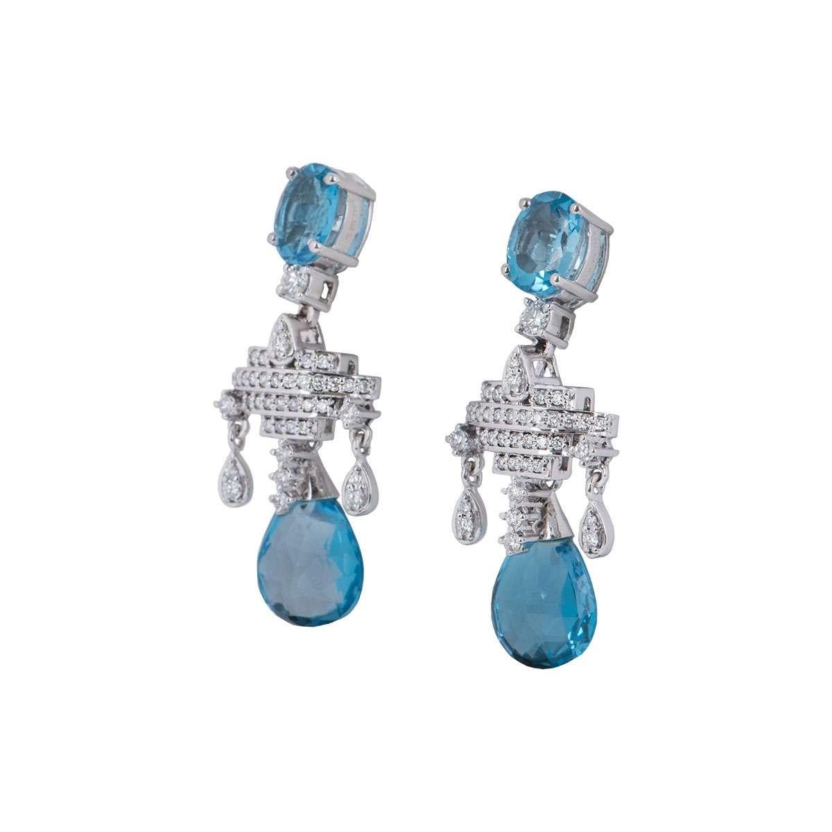 A pair of 18k white gold diamond and aquamarine drop earrings. Each earring is formed of an oval cut aquamarine followed by a diamond set abstract motif, which is then complemented by a detachable briolette cut aquamarine. The aquamarines have a
