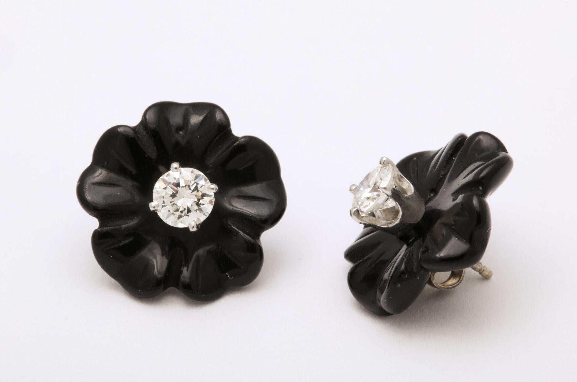A classic pair of diamond studs .25 each with carved floral black coral jackets