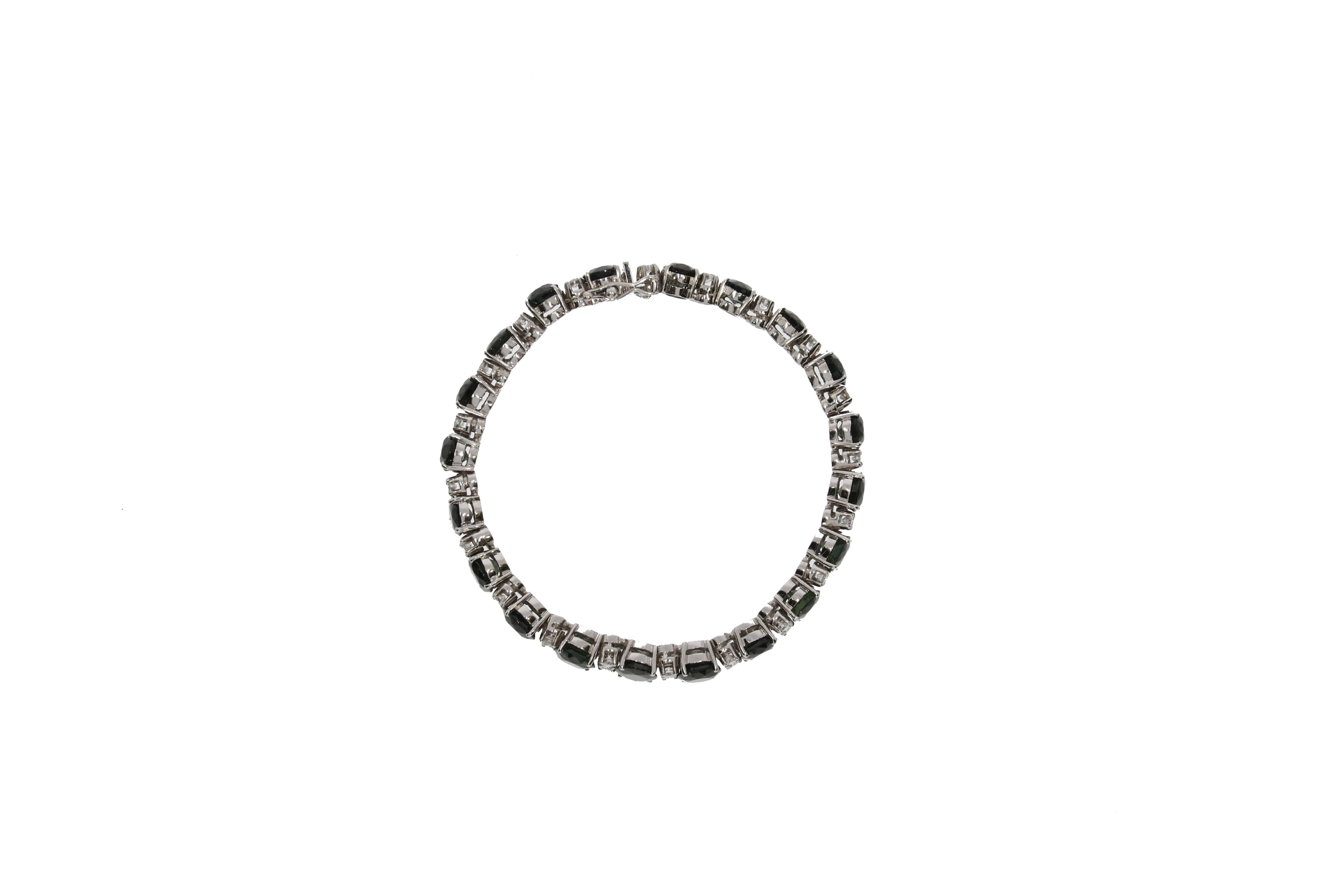 A classic yet modern white gold and rodium plated bracelet. Designed as a gently graduated line of 40 brilliant-cut diamonds (in total approx.: 2,5 carats) and 20 oval facetted black sapphires (in total approx.: 35 carats). The stones are prawn set.