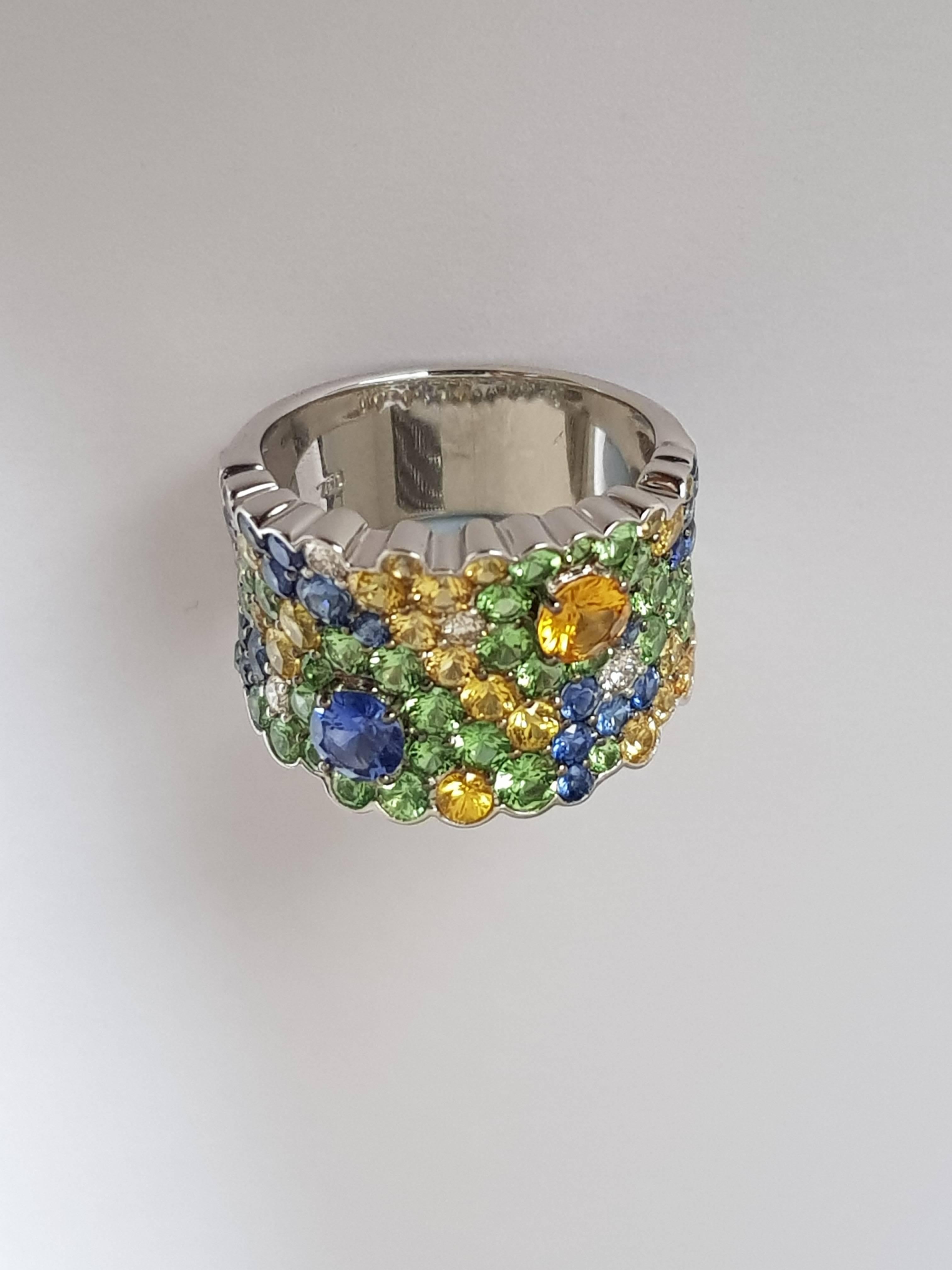 Sapphire, Tsavorite and Diamond Ring
4 diamonds ca 0.14 ct
24 blue sapphires 1.39 ct
24 yellow sapphires 1.52 ct
38 tsavorites 1.92 ct
18 karat white gold
size 53 (can be adjusted one size up or down)