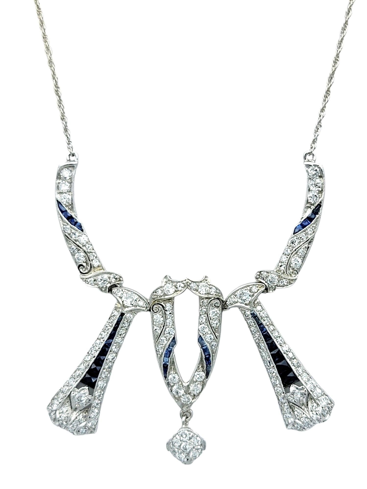This exquisite necklace features a mesmerizing combination of diamonds and blue sapphires set in 14 karat white gold. The geometric design of the necklace captures the elegance and sophistication of the Art Deco period, with intricate details that