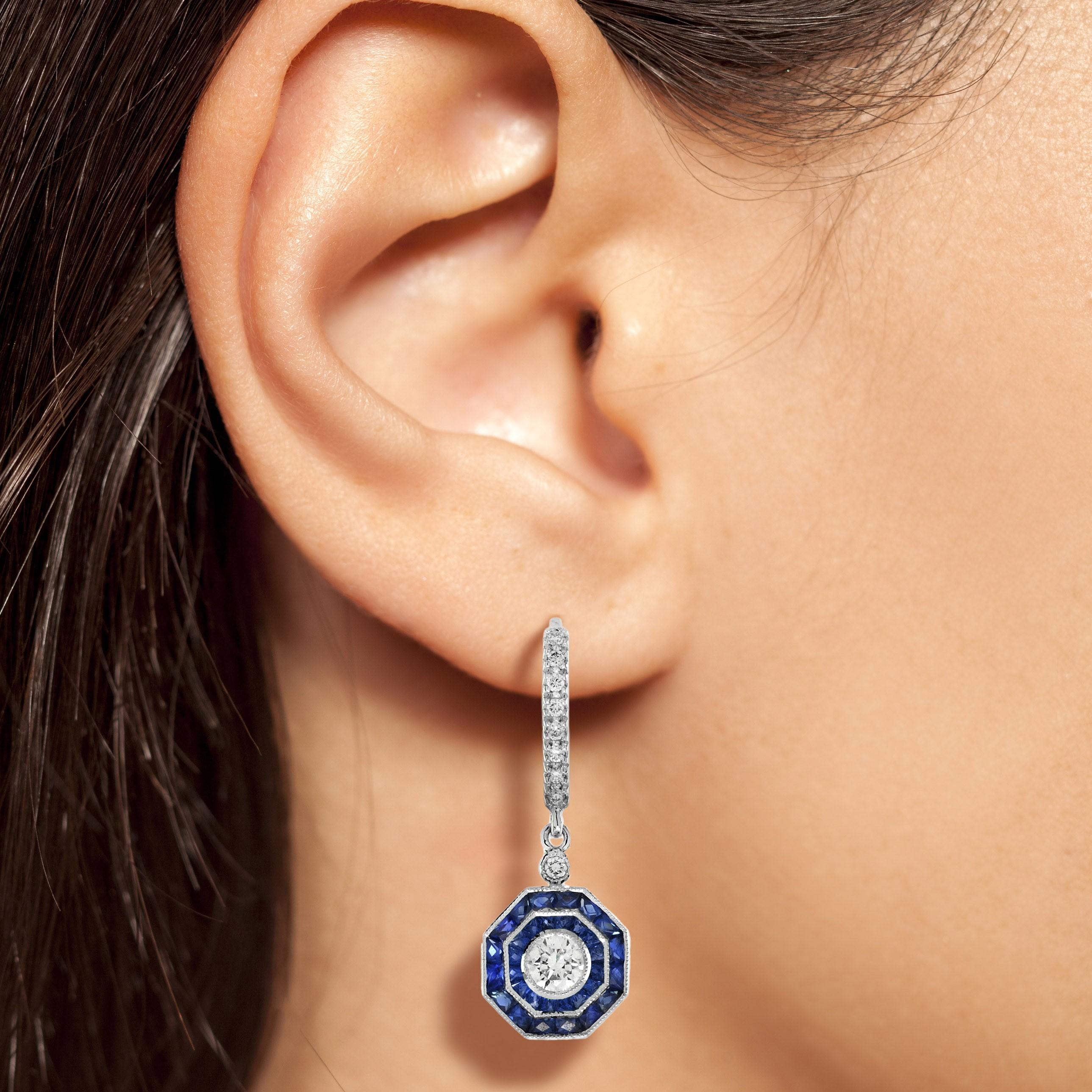 Exquisite early Art Deco inspired Diamond and Blue Sapphire earrings. The central Diamond is surrounded by finely set double halo sapphires to an outer creating a chic octagonal form. The earrings are perfectly worn with the same design halo