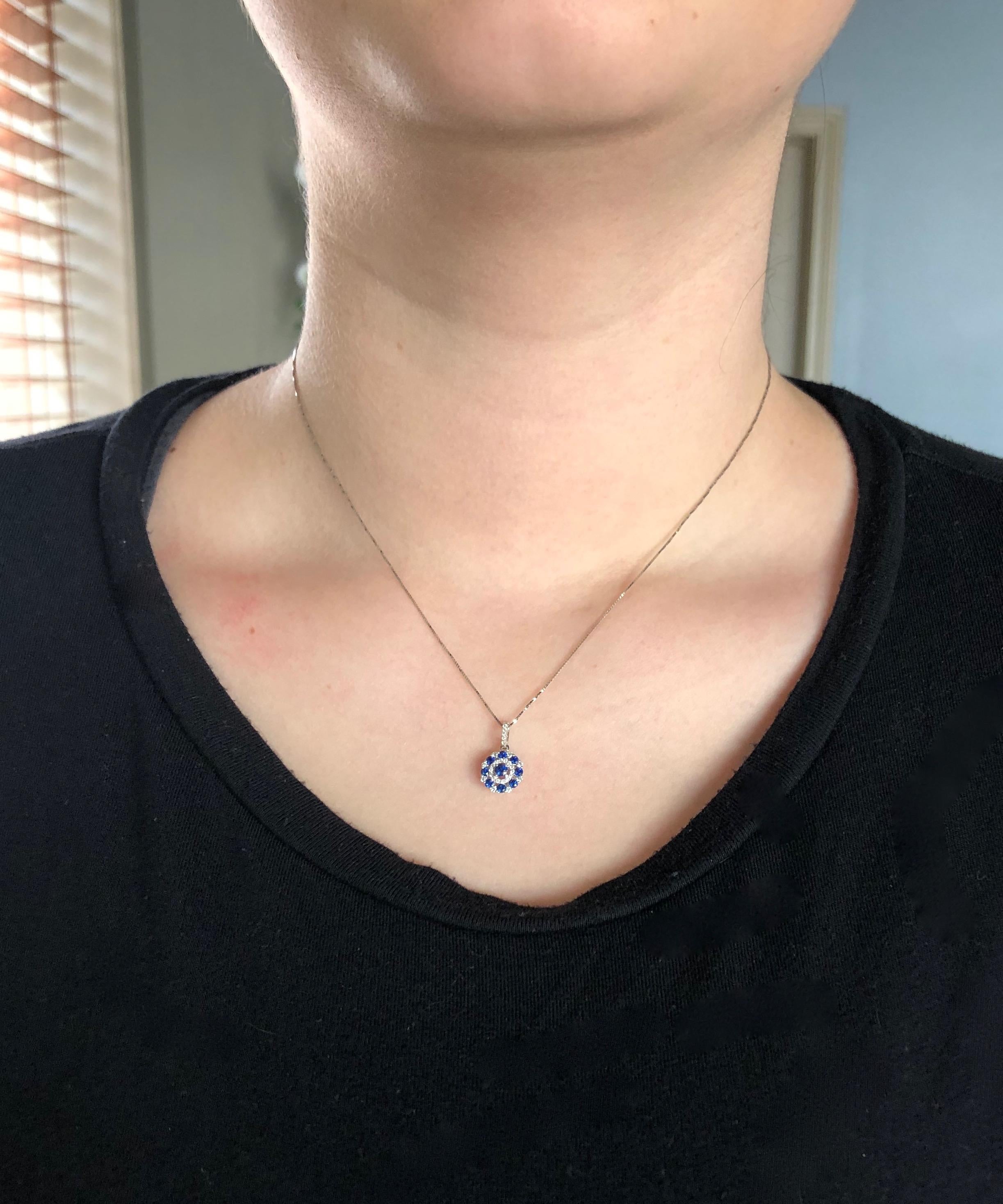 This beautiful necklace features a unique halo style pendant consisting of 28 Round Brilliant Cut Diamonds and 9 Round Cut Sapphires. 

Gemstone: Sapphire & Diamond
Gemstone Carat Weight: .40CTW of Round Cut Sapphire 
Diamond Cut: 28 Round Brilliant