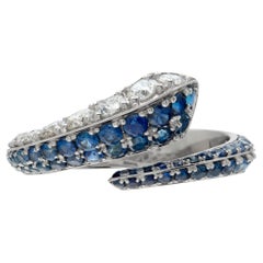 Diamond and blue sapphire crossover ring in white gold.