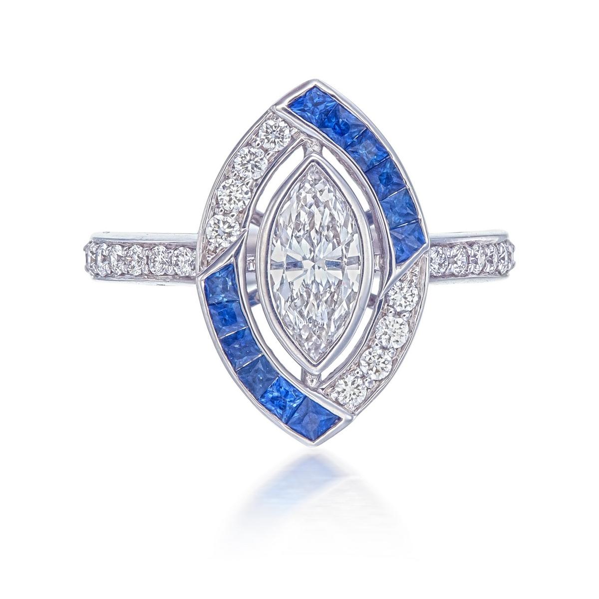 A brand new diamond and blue sapphire ring in 18 Karat white gold. This modern vintage ring's design was inspired by art deco themes. 

The centre marquise diamond is approximately 0.67 carat and H-I colour and VS clarity. 

The ring also has 22