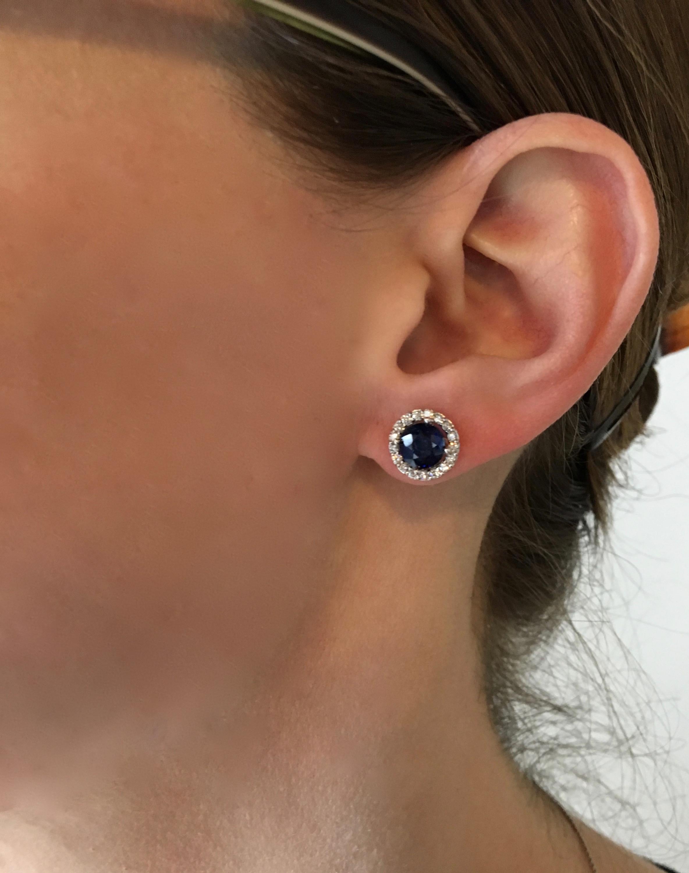 These halo style earrings feature two beautiful Blue Sapphires surrounded by approximately .50CTW of Round Brilliant Cut Diamonds.

Gemstone: Diamond & Sapphire
Gemstone Carat Weight: 6.33mm Round Cut Blue Sapphire
Diamond Carat Weight: