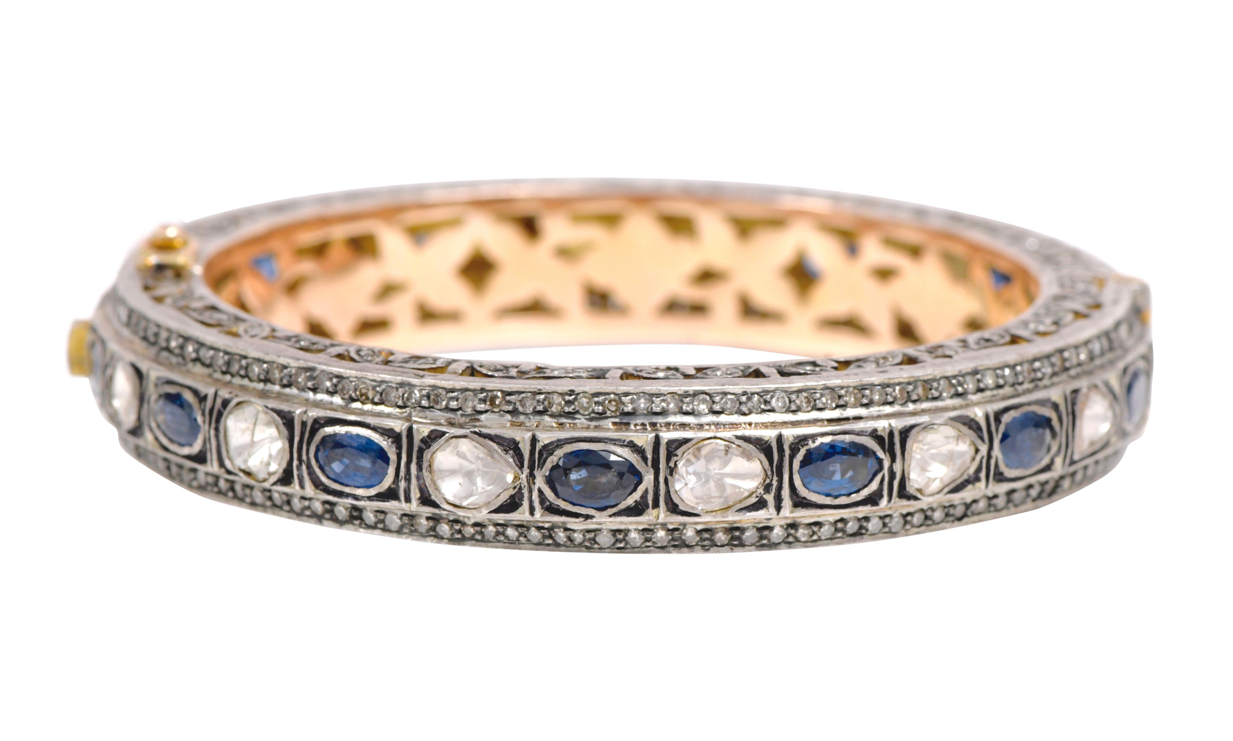 Diamond and Blue Sapphire Tennis Bangle in Art-Deco Style

This Victorian period art-deco atypical polki diamond and vivid blue sapphire bangle is marvelous. The uneven triangle and U-cut flat polki diamond solitaires alternated with oval shape