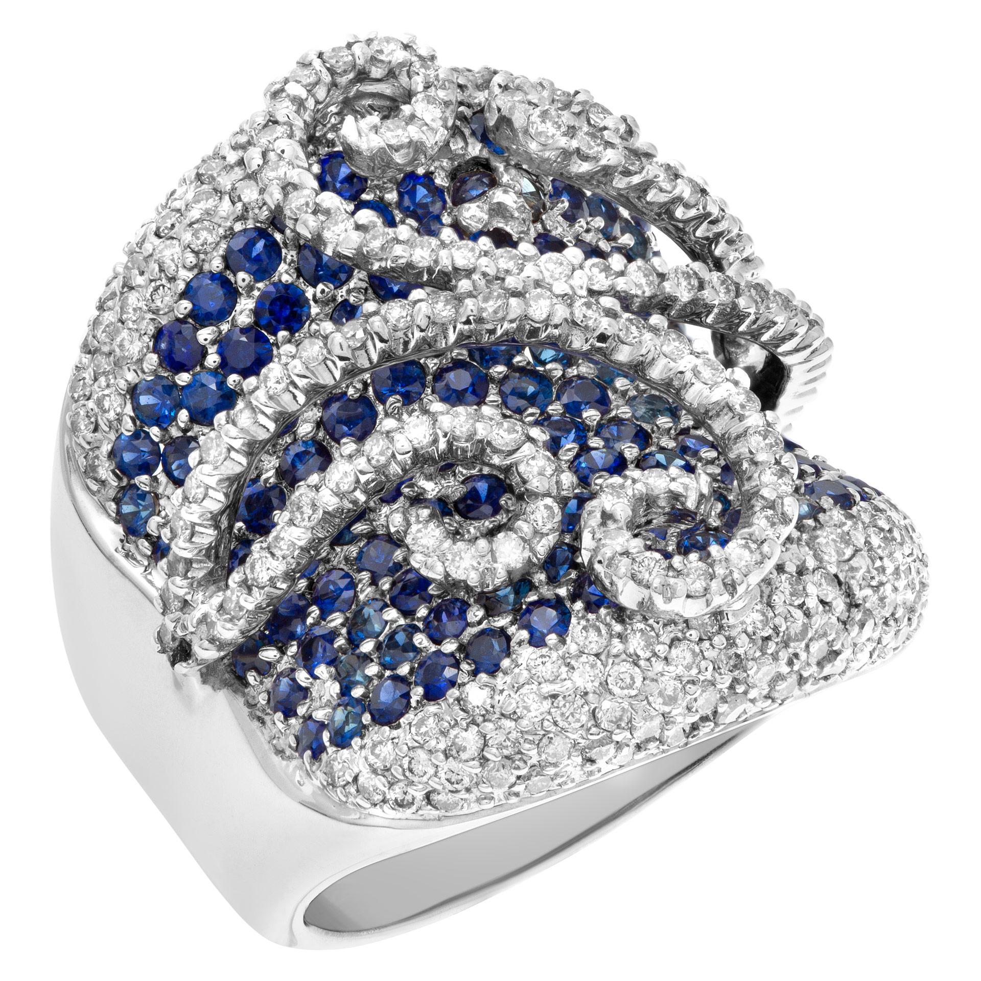 Swirls and more! Ring with approximately 1 carat in diamonds and 1 carat in blue sapphires all set in 18k white gold. Shank width on the top 24mm, back 7.4mm. Size 4.75.  This Diamond ring is currently size 4.75 and some items can be sized up or