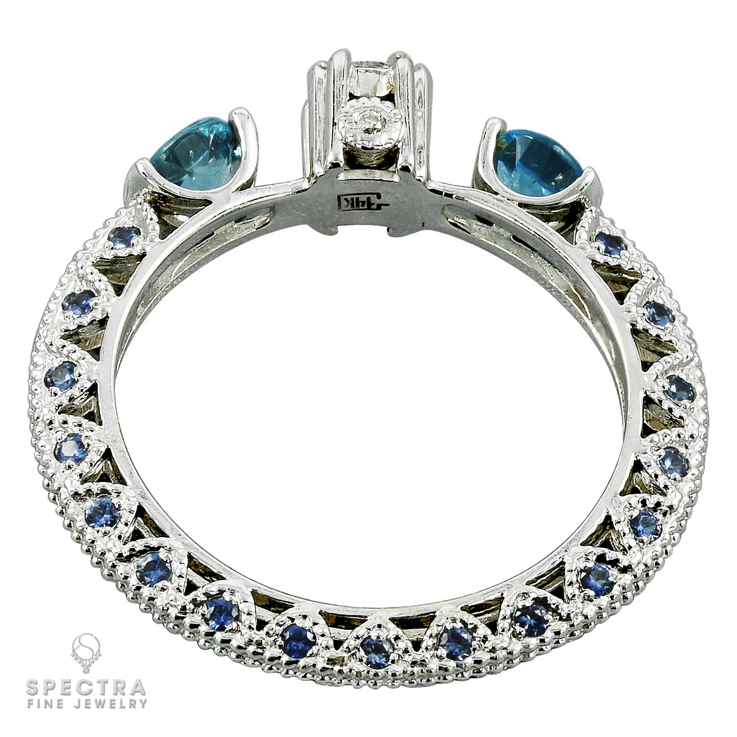 A cocktail ring featuring two blue topaz gemstones in the center and three round diamonds.
Total weight of the diamonds is 0.3 carats.
The band of the ring is encrusted with 34 topaz stones.
Metal is 14k white gold; gross weight is 3.3 gr.
Size 7.75.