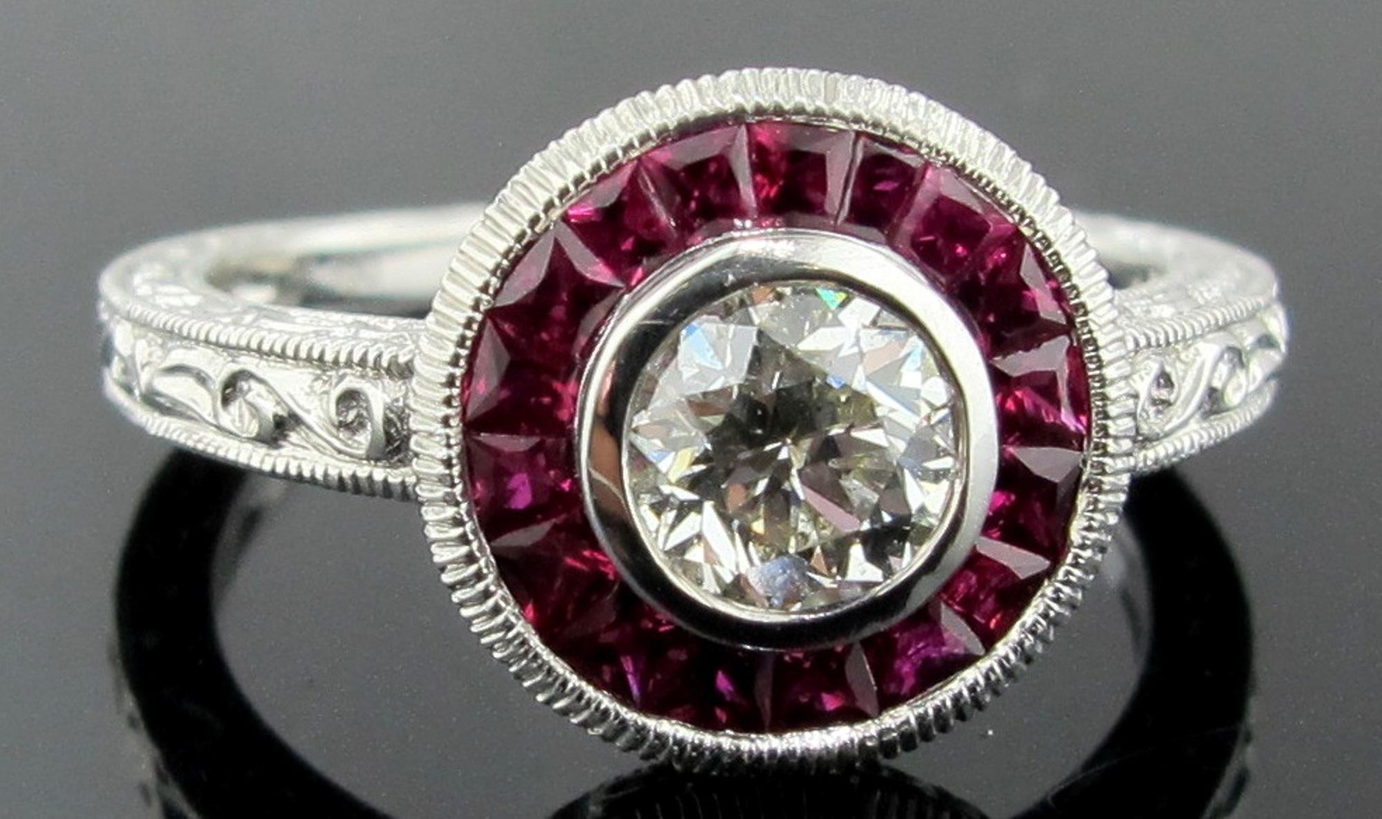 18 karat white gold Diamond ring with a center round cut diamond weighing 0.50 carats.  The center diamond is surrounded with 0.60 carats of calibrated rubies.  Ring size is 6.5.