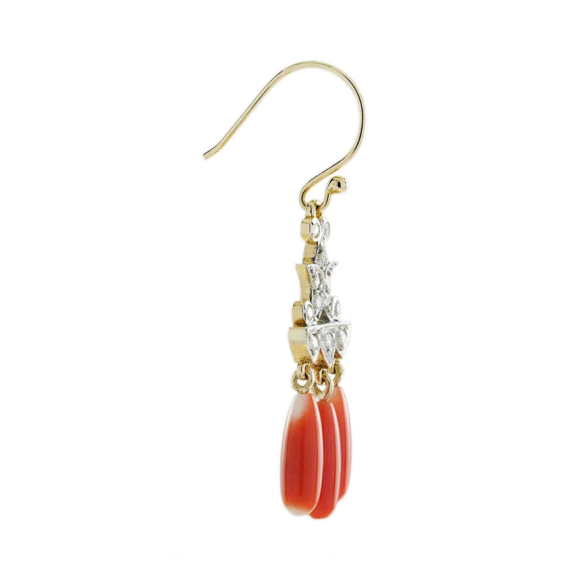 Superbes boucles d'oreilles chandelier de style Art déco, ornées de diamants complexes et de trois gouttes de corail en cascade. Les diamants sont disposés selon un motif géométrique et symétrique, créant un effet de chandelier spectaculaire. En