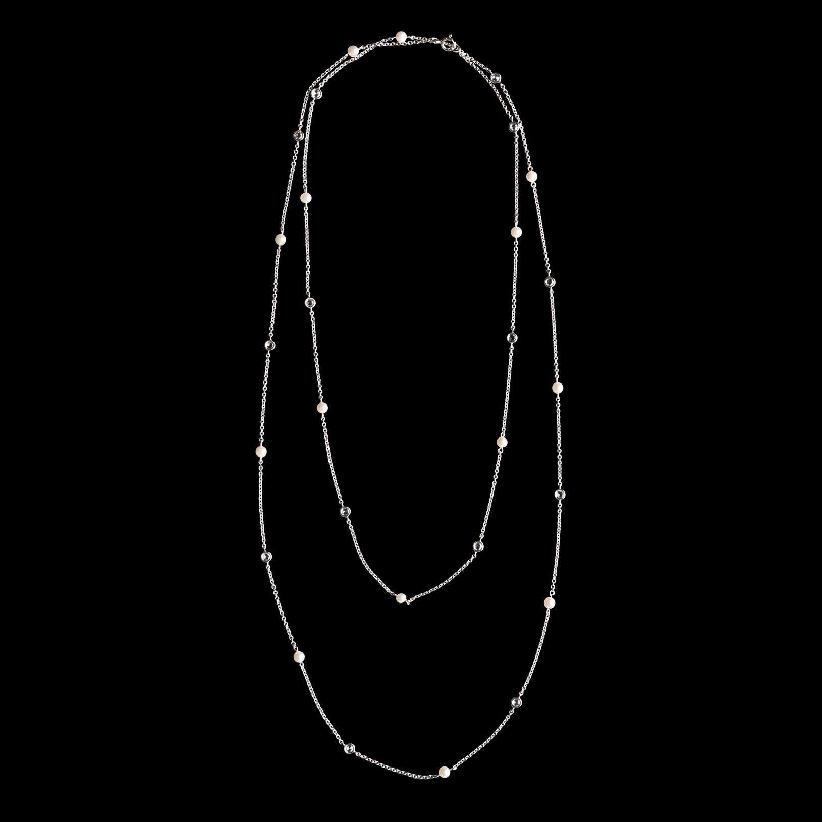 The 18k white gold station long chain necklace is delicate and elegant. Alternating with 14 bezel-set rose-cut diamonds and 3.5mm cultured pearls, the necklace can be worn full length or doubled up. Total diamond weight is 0.42 carat, the necklace