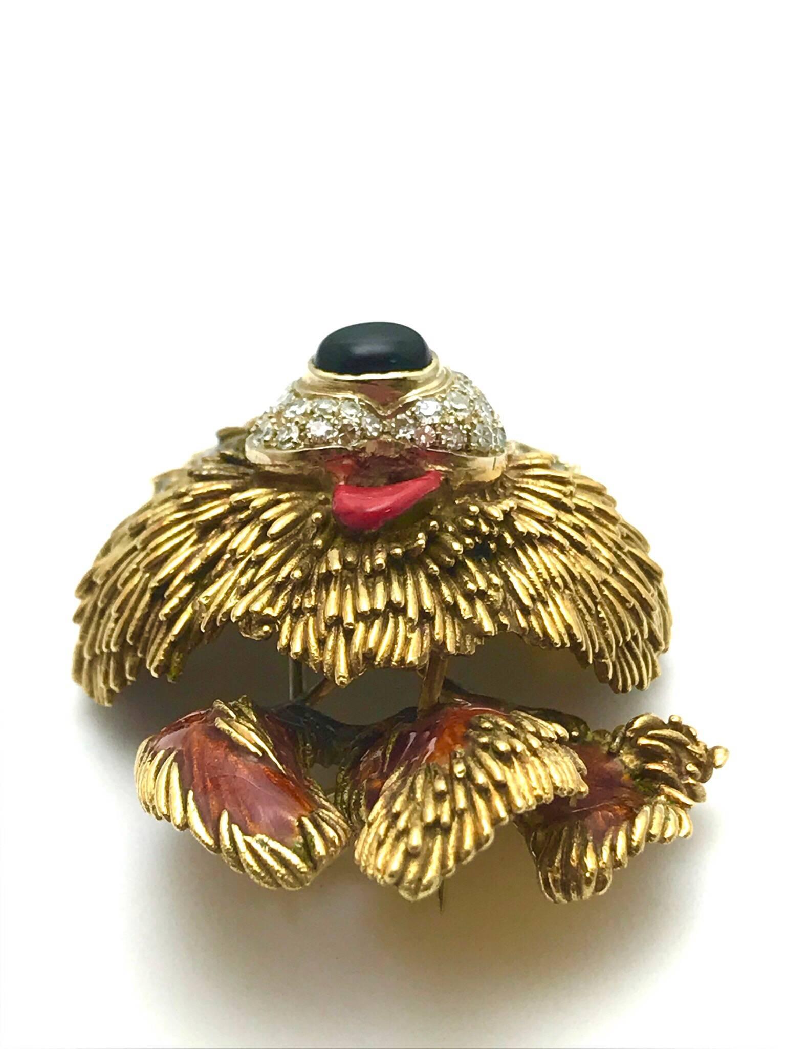  Italian brooch rendered in 18-karat textured yellow gold simulates a stylized version of a handsome dog, with a pair of round emeralds simulating the animal's eyes, an oval cabochon black onyx nose, surrounded by pave diamonds, and a red enamel