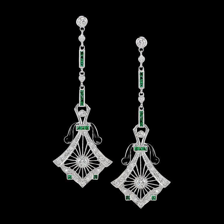 These antique dangle drop earrings are one of the most whimsical pieces of jewelry. When worn, the black enamel forms a beautiful contrast, which makes the diamonds and emerald stand out even more. Set in 14K white gold, these Art-Deco style