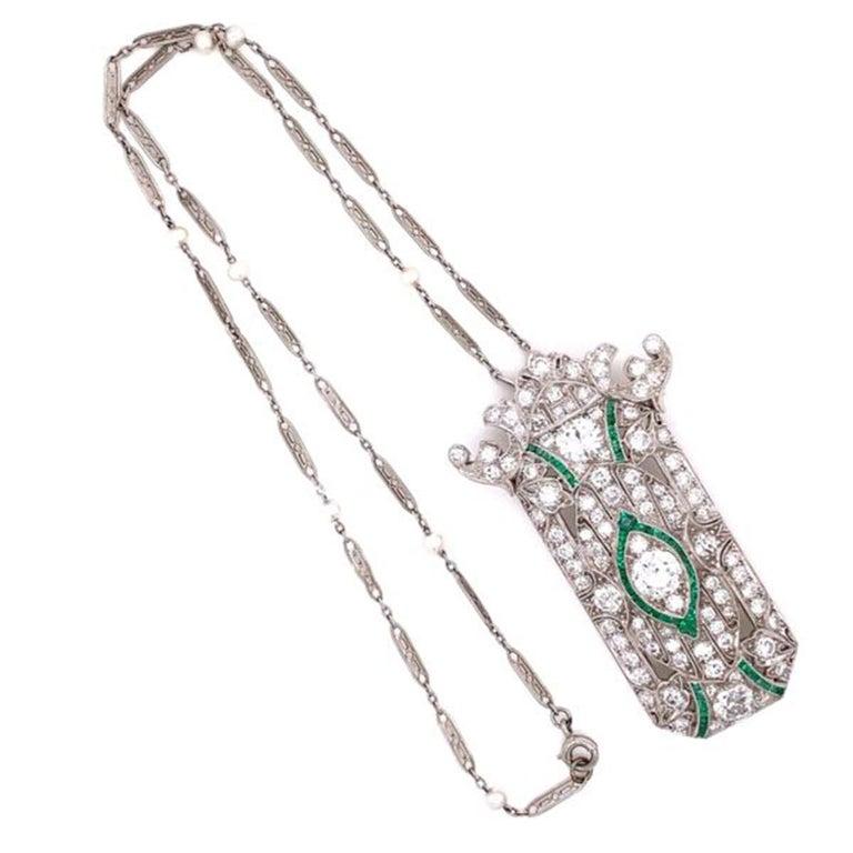 Simply Beautiful, Elegant and finely detailed Art Deco Style Diamond and Emerald Platinum Brooch Pendant Necklace, suspended from a 16” chain.  Handmade and set with Old European cut Diamonds approx. 5.90 total Carat weight and Emeralds approx. 1.50