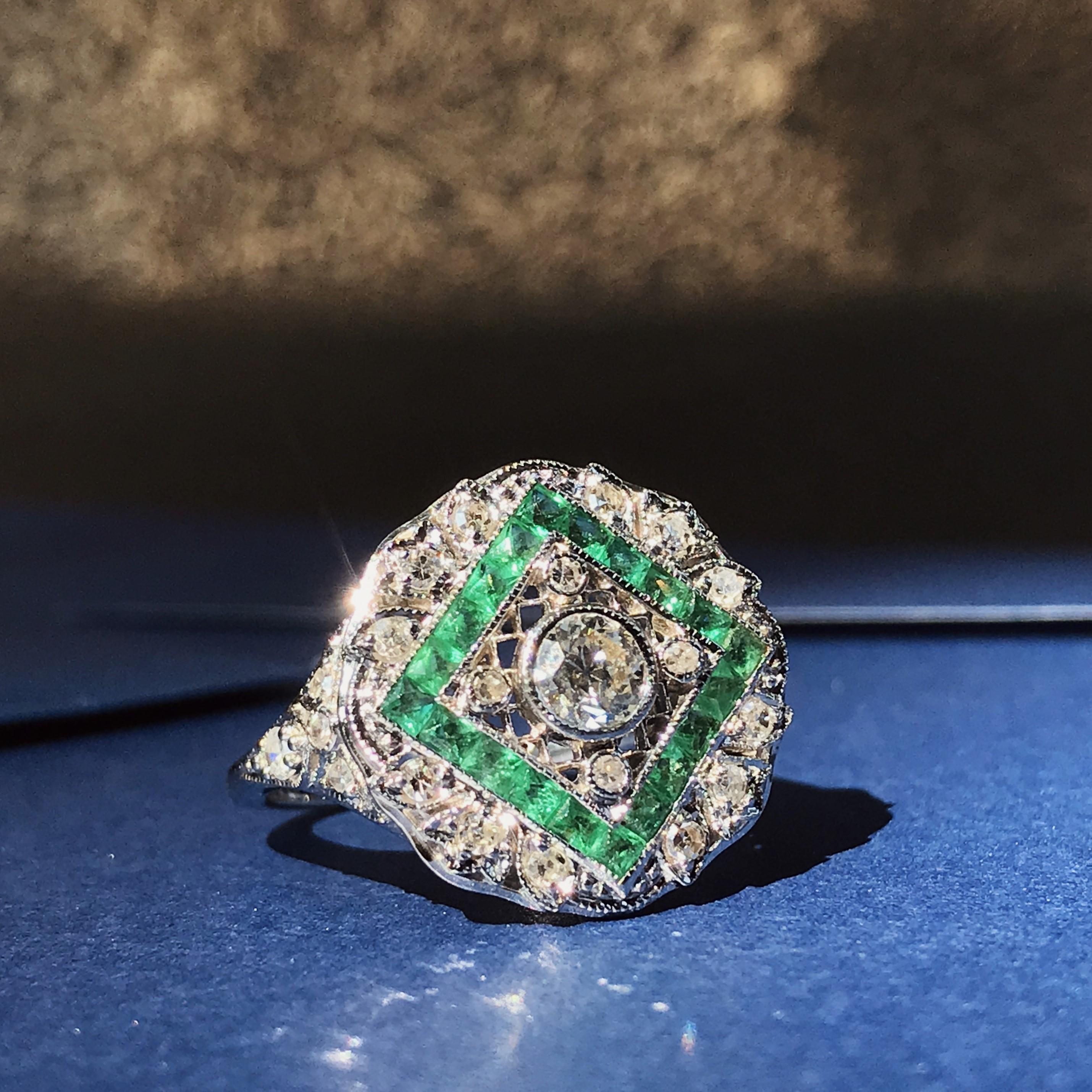 An exquisite Art Deco style emerald and diamond ring, crafted in 18k white gold. This stunning designed ring is encrusted with total of twenty-five round diamonds and twenty French cut emerald, producing a beautiful and bold statement to your hand.