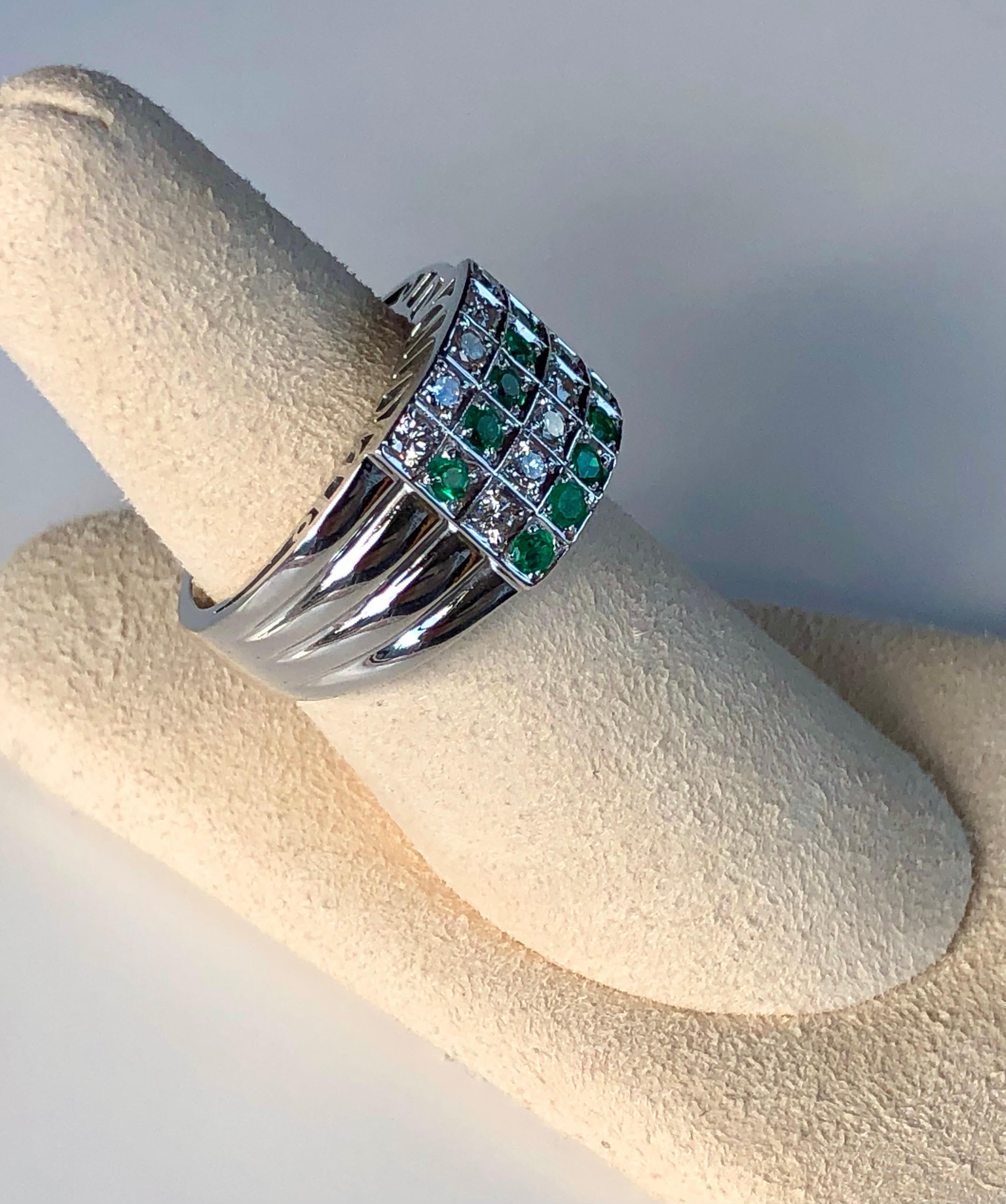 This unique band ring has been set with 20 beautifully round-cut diamonds and round-cut natural quality Colombian emeralds. The ring measures 11.5mm at the widest and tapers down to 4.5mm at the shank. Total diamond(G-VS) and Colombian emeralds
