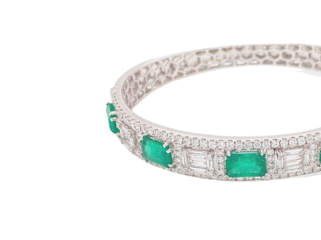 Bangle bracelet made with real/natural diamonds and emeralds. Emerald Total Weight: 4.75 carats. Diamond Total Weight: 2.95 carats. Diamond Color: G-H. Diamond Clarity: VS. Diamond Cut: Baguette and brilliant cut diamonds. Mounted on 18 karat white