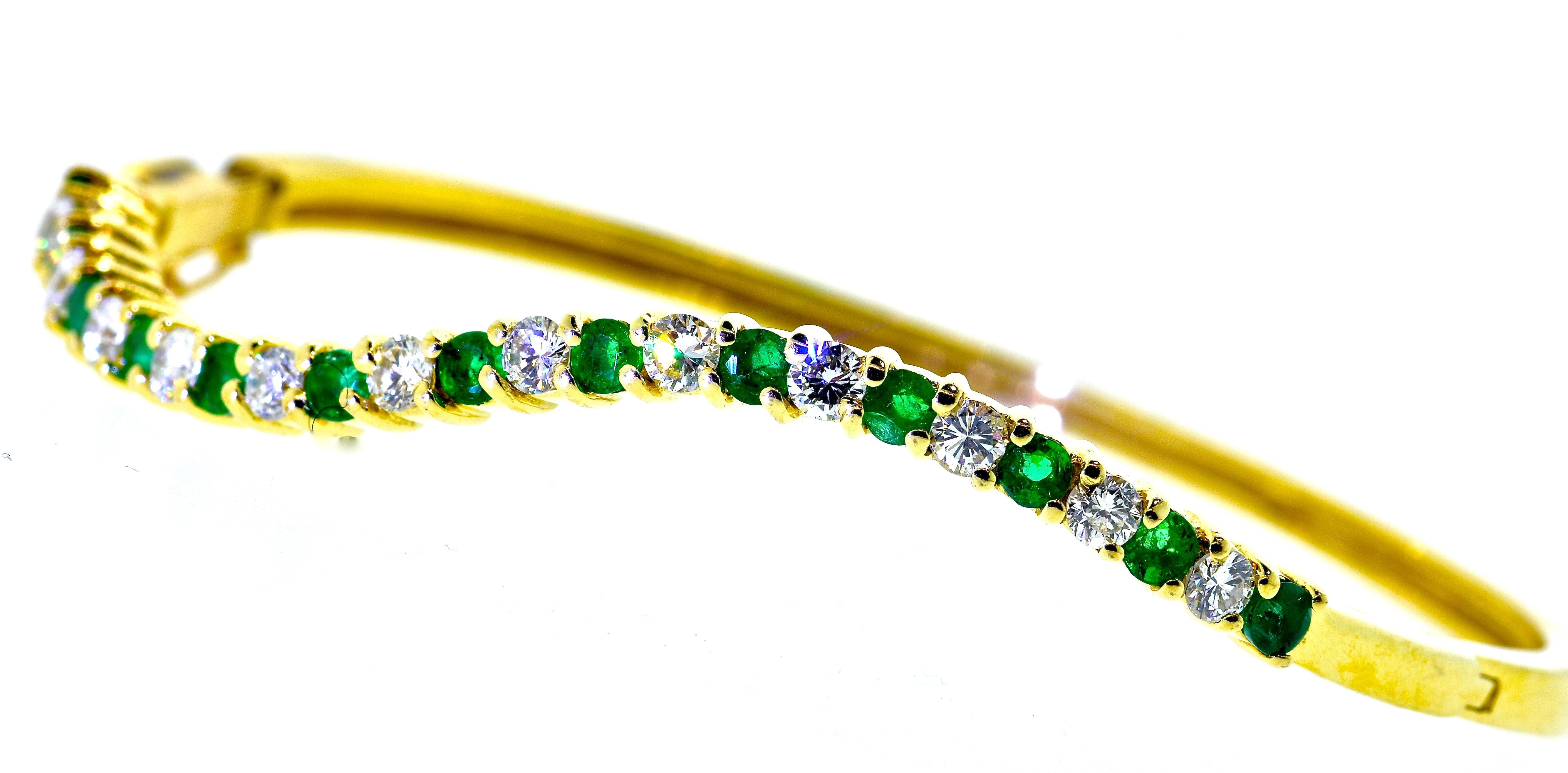 Emerald and diamond bangle bracelet in yellow gold and possessing fine white brilliant cut white diamonds all well cut and well matched.  These 12 diamonds are estimated to weigh 1.0 cts.  There are 13 fine bright green natural emeralds.  These