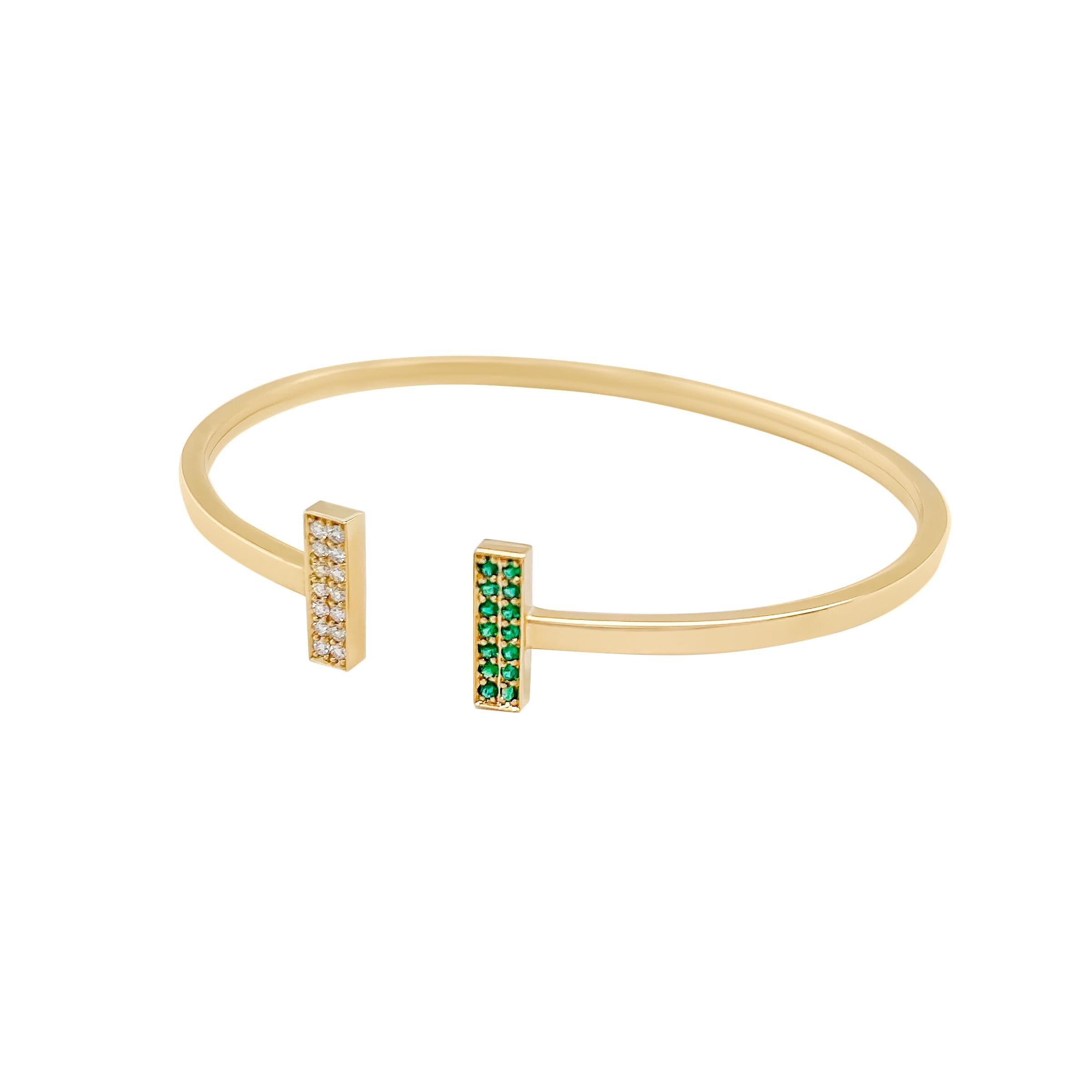 Cet élégant bracelet en or 18 carats présente deux barres parallèles, l'une pavée de diamants éblouissants et l'autre de riches émeraudes. Sa conception flexible garantit un port sans effort, vous permettant de l'enfiler et de l'enlever facilement