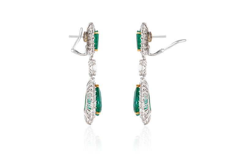 Diamond and green emerald drop earrings, finely crafted in platinum and 18 k yellow gold, featuring pear shaped Brazilian emerald drops, weighing 6.72 carat and 6.38 carat. The top, Brazilian emeralds weigh 1.59 carat and 1.33 carat. Both top and