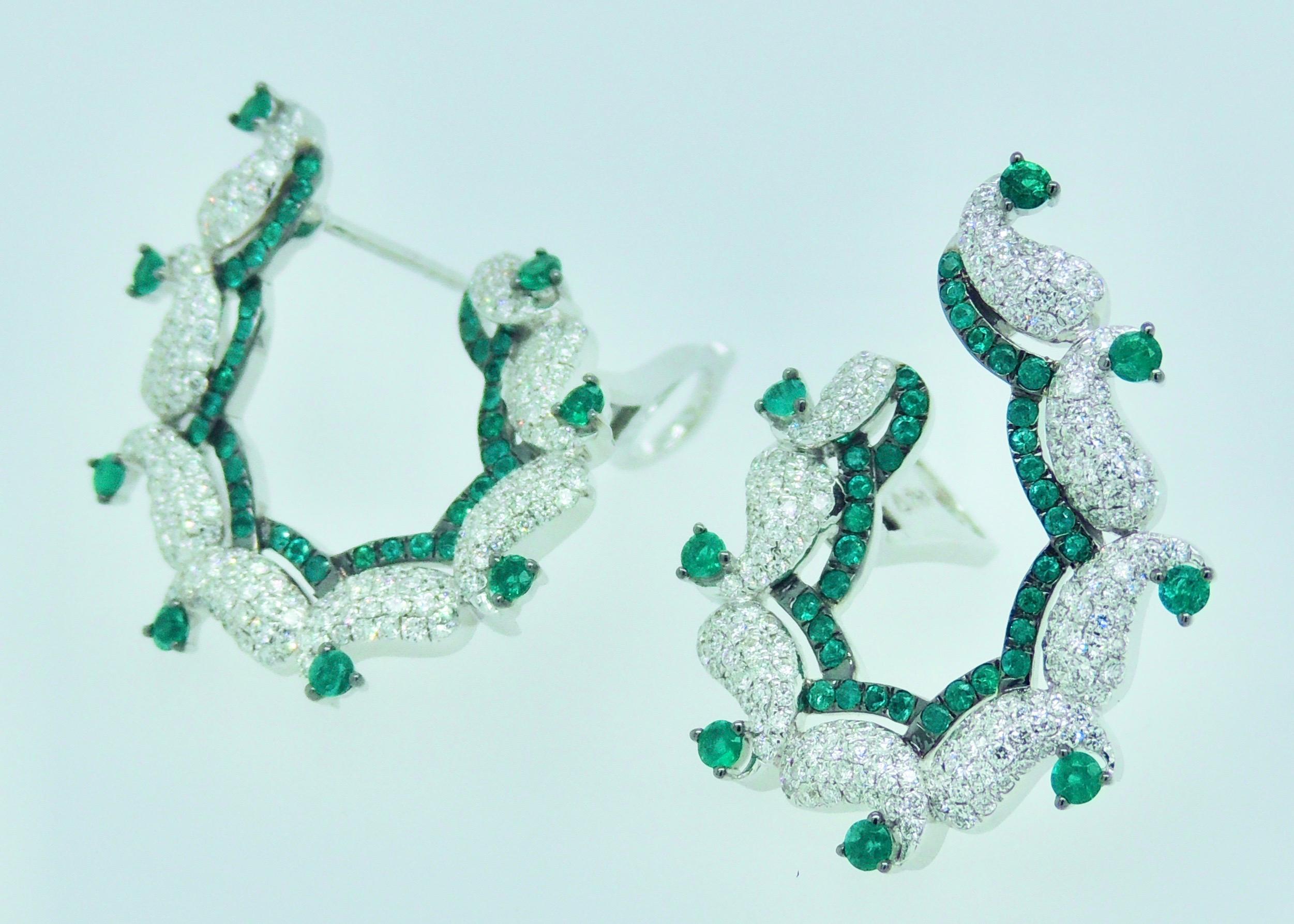 Stunning diamond and emerald hoop earrings in 18 karat white gold.

These paisley-inspired, diamond earrings with handset diamonds and emeralds create the perception of movement yet are designed to sit perfectly on your ears.

•	Total Diamond