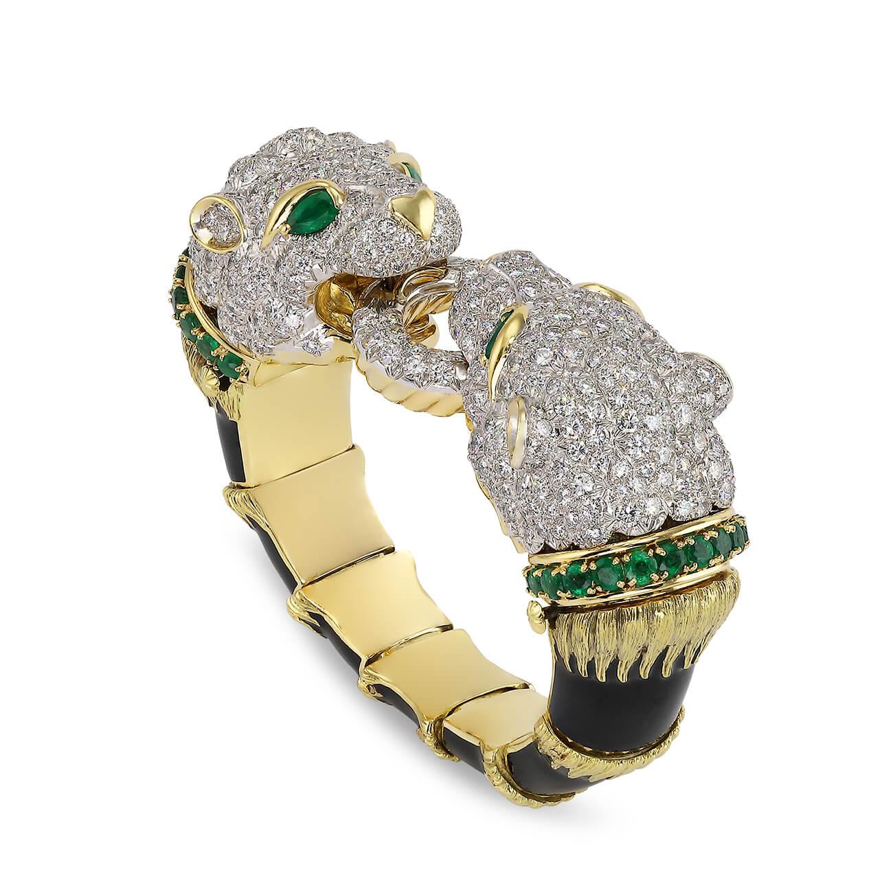 Vintage bangle part of the David Webb ‘Kingdom Collection’, two opposing round brilliant cut diamond filled lion heads on an 18k yellow gold and platinum bangle, each head detailed with emerald eyes and an emerald collar, both grasping a diamond and