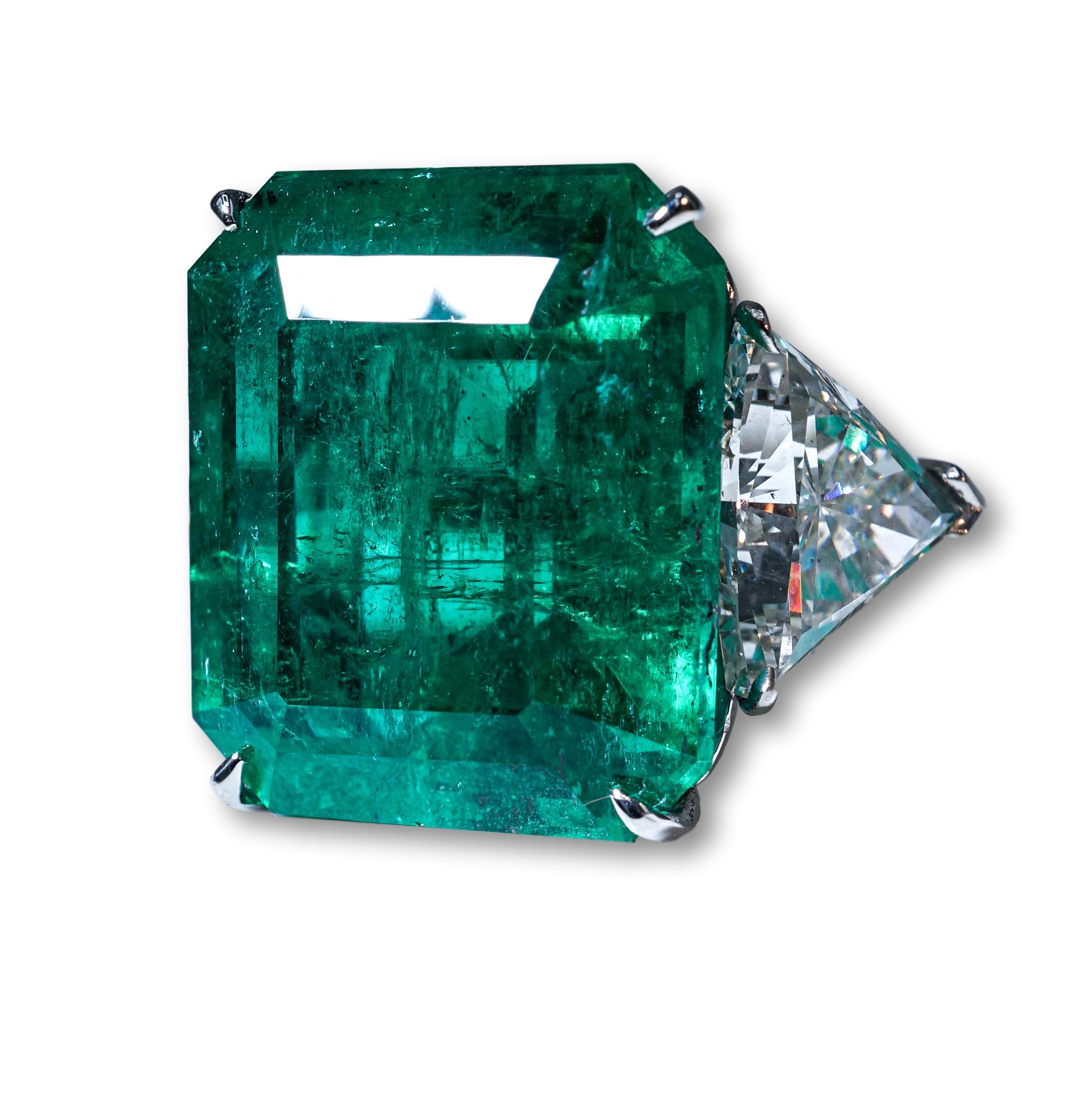 A important Diamond and Emerald Ring . Emerald certified by AGL - 18.73ct, two side trillion diamonds - each certified by GIA, 2.29ct F/SI1 and 2.27ct G/SI1. 

SKU#R-01208