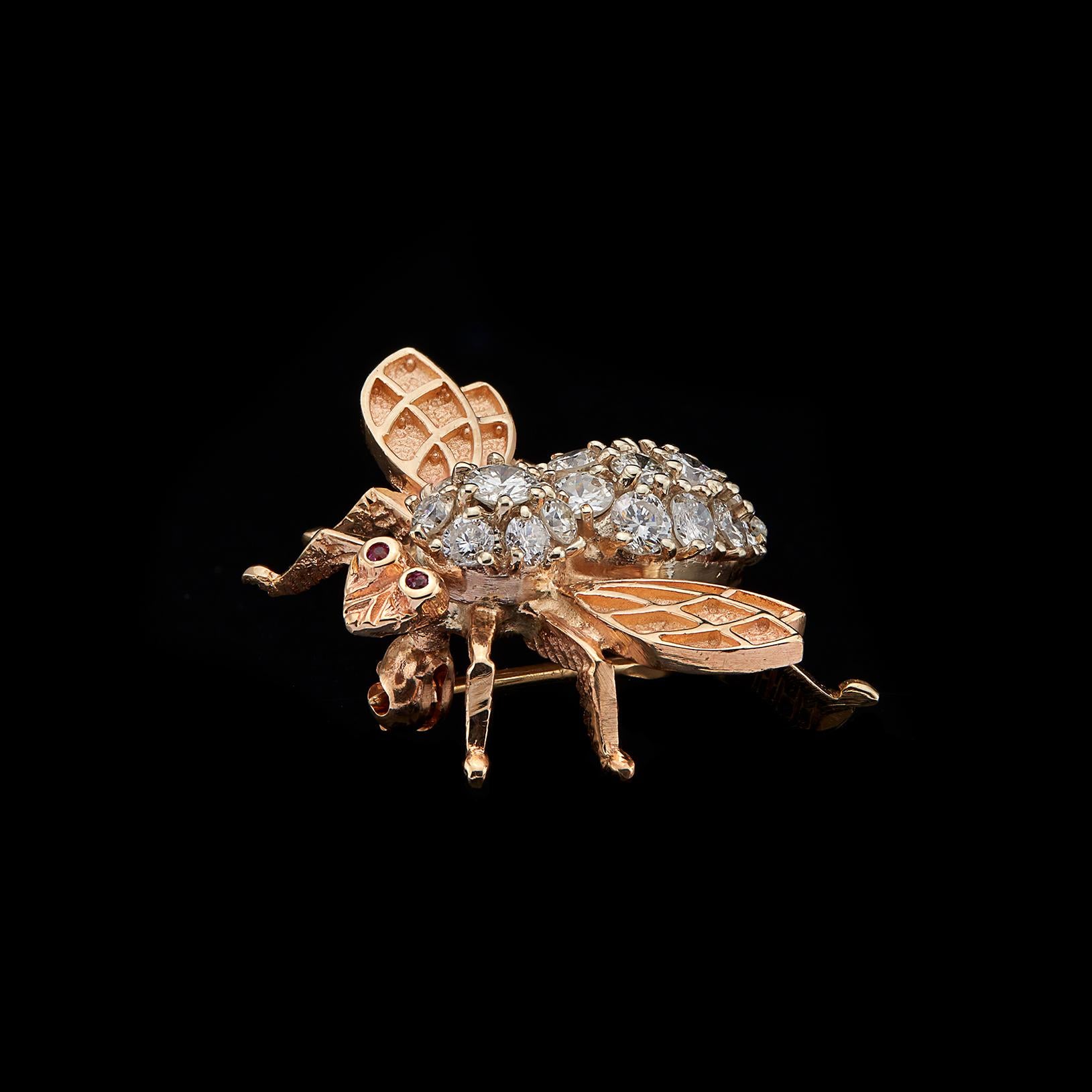 Be charmed with this diamond and 14k gold bee brooch! The body is set with 20 round brilliant-cut diamonds totaling approximately 1.11-cts (G-H-I/SI), with ruby eyes and textured wings. The bee weighs 5.6 grams and measures 1 1/8 x 7/8in. Add a