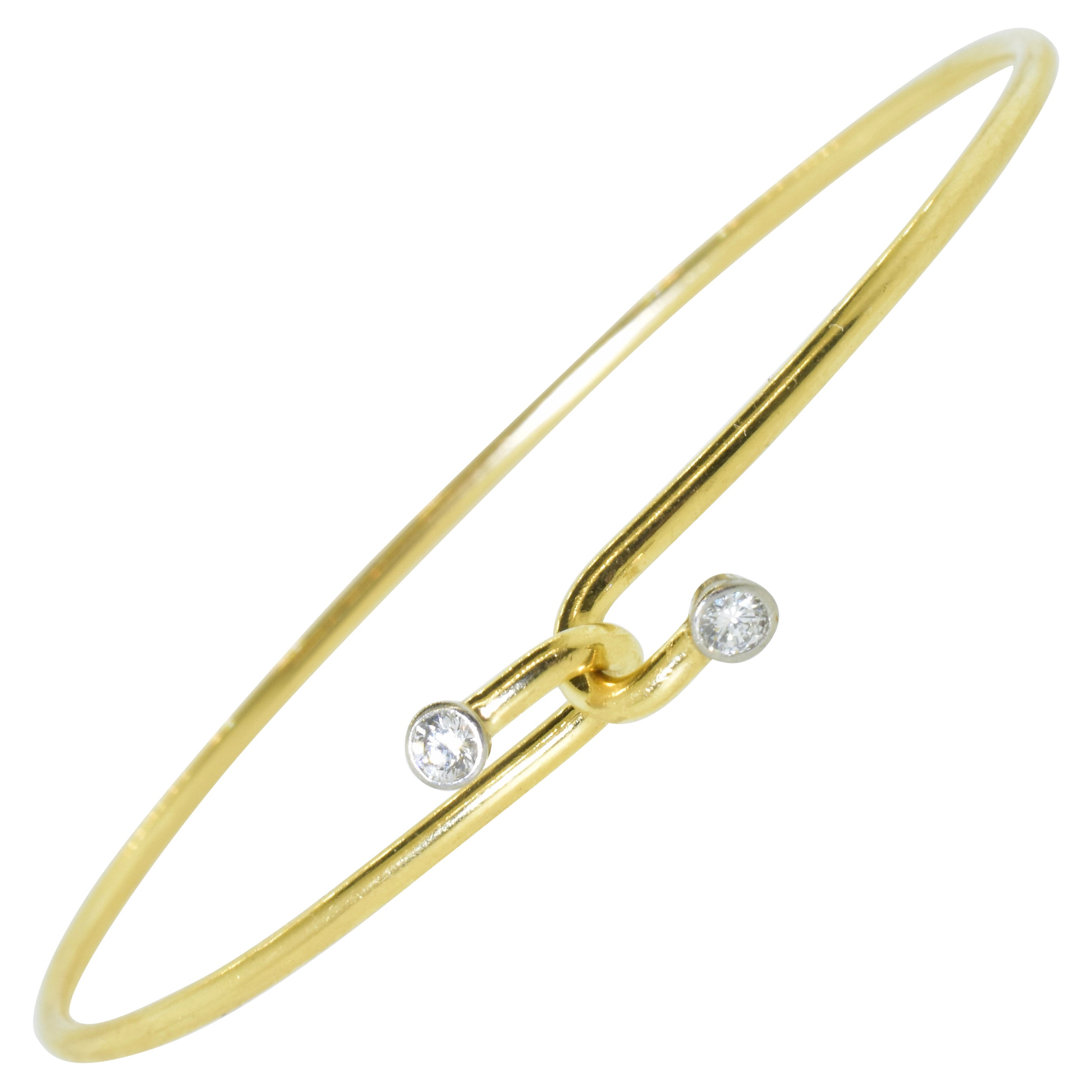 Tiffany & Co. flexible bracelet centering two diamonds, this 14K yellow gold and platinum bracelet is easy to wear.  It has a by-pass clasp with a diamond on each side of the interlock front clasp.  The bracelet consists of gold wire (round in cross