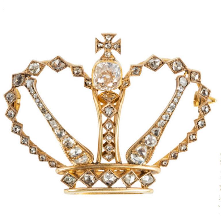 A royal crown of stylized design, bezel set with a cushion-cut diamond, below a rose
diamond Maltese cross, the borders and bands set with rose diamonds that graduate in
size, many within diamond-shaped bezels. Mounted in 14k gold.

19th century.