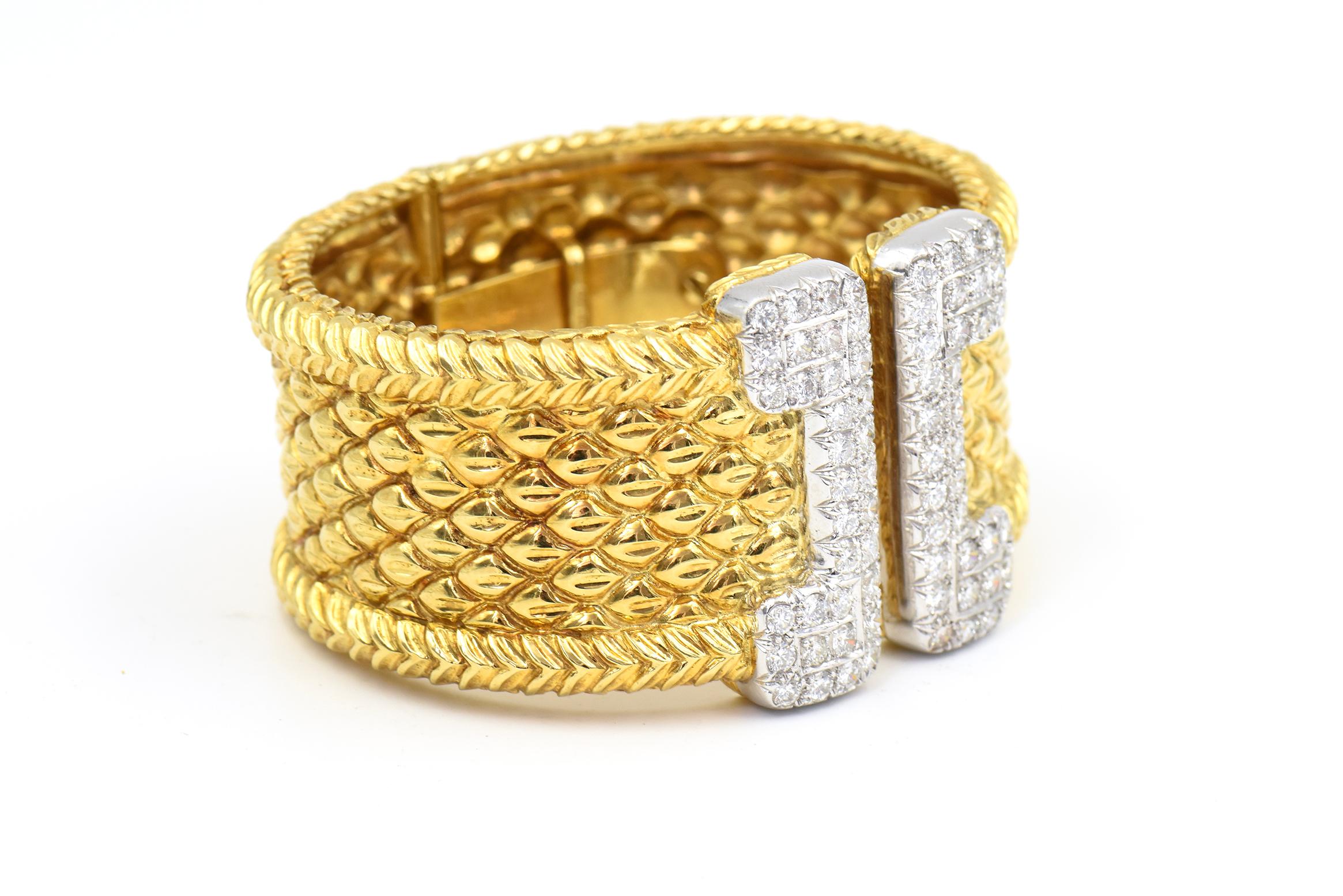Impressive diamond and 18k gold wide hinged cuff bracelet featuring a highly stylized gold cuff terminating with diamond edges.  The bracelet contains 68 round diamonds for approximate diamond weight of 5.5 carats.  The hinge on the back makes it