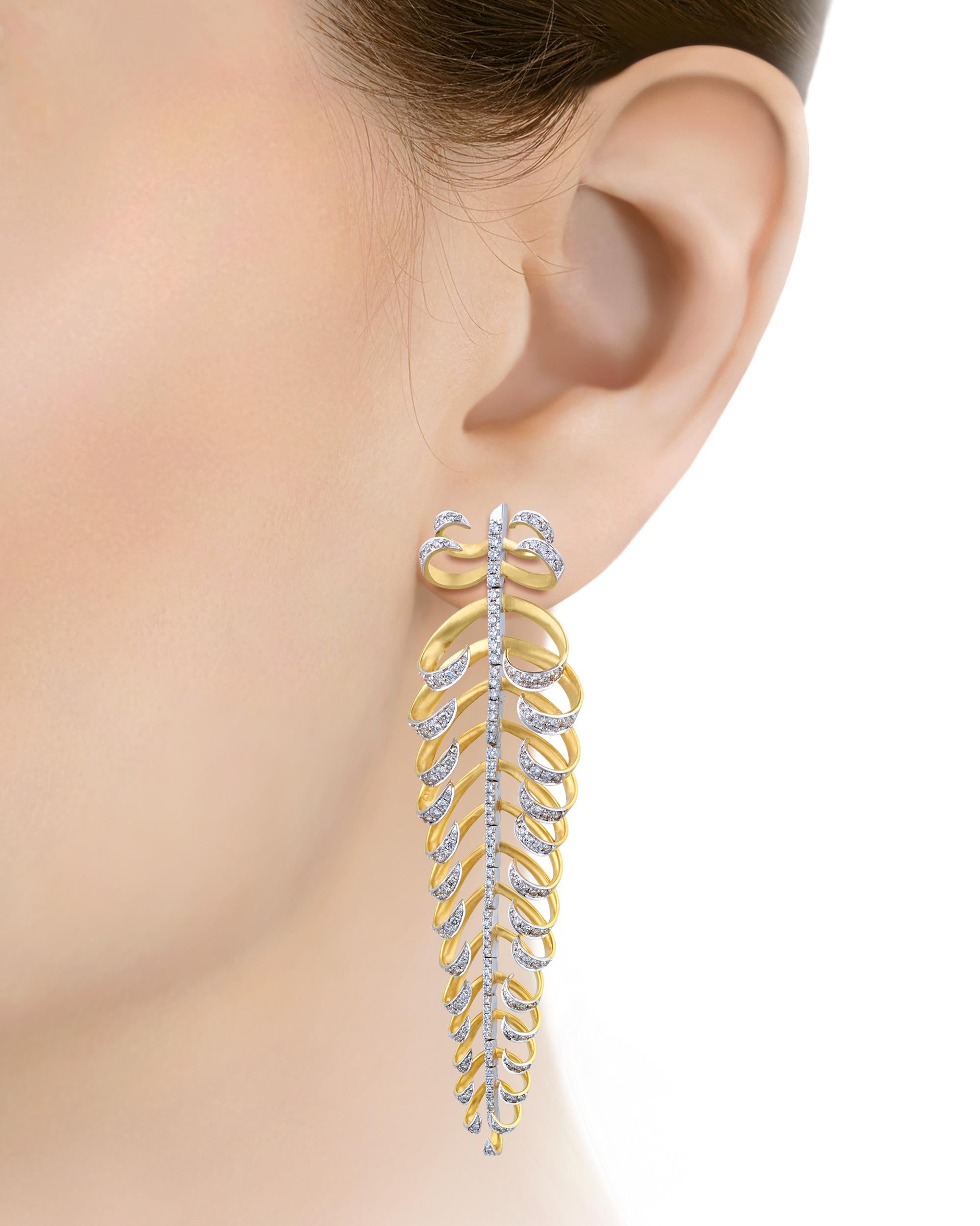 Dieses modische Paar Ohrringe aus Gold und Diamanten setzt ein markantes Zeichen. Jeder der kunstvollen blattförmigen Ohrringe ist fachmännisch aus glänzendem 18-karätigem Gold gefertigt und trägt eine schillernde Reihe weißer Diamanten von
