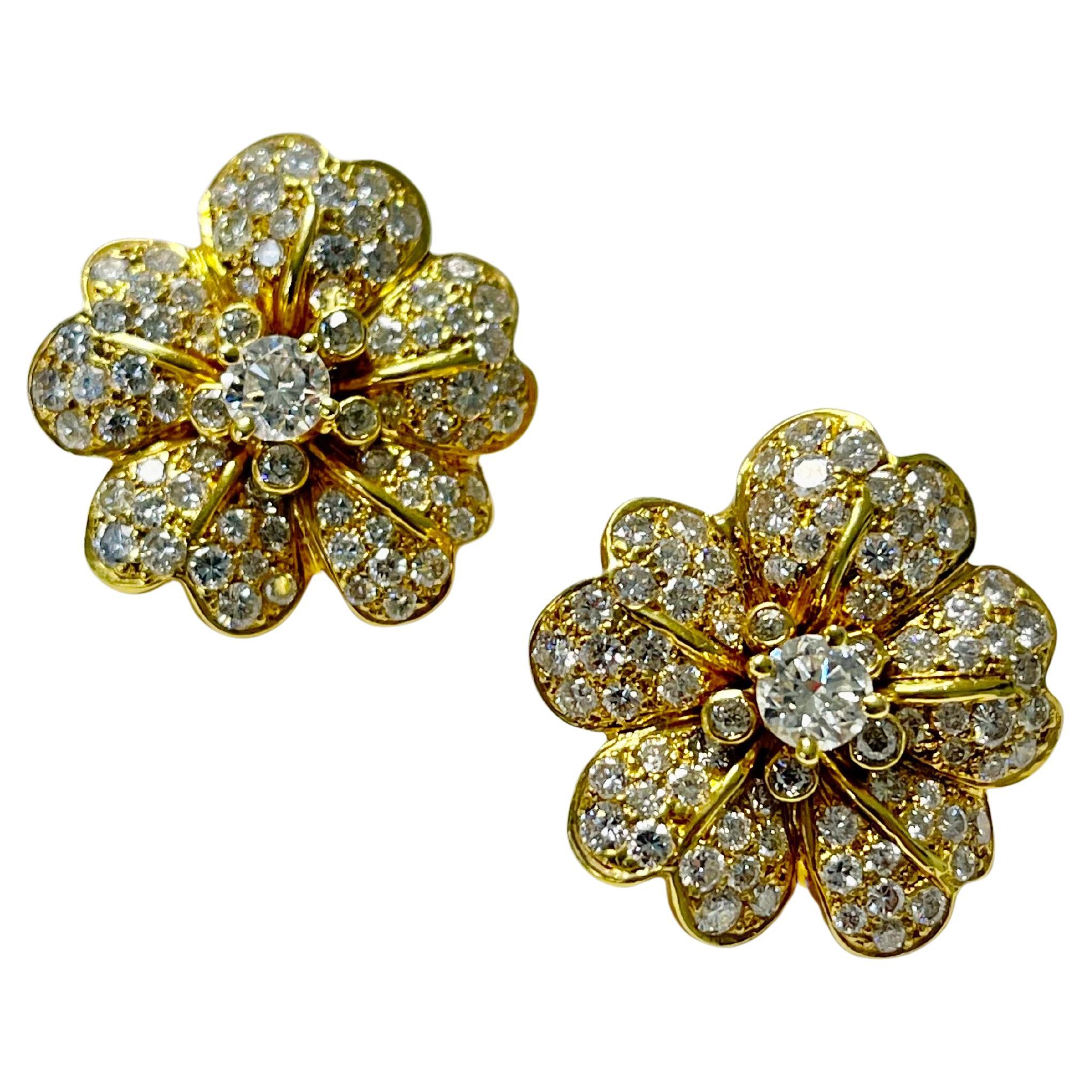 Boucles d
oreilles en or jaune avec fleurs en diamant et or.