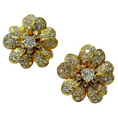 Boucles d
oreilles en or jaune avec fleurs en diamant et or.