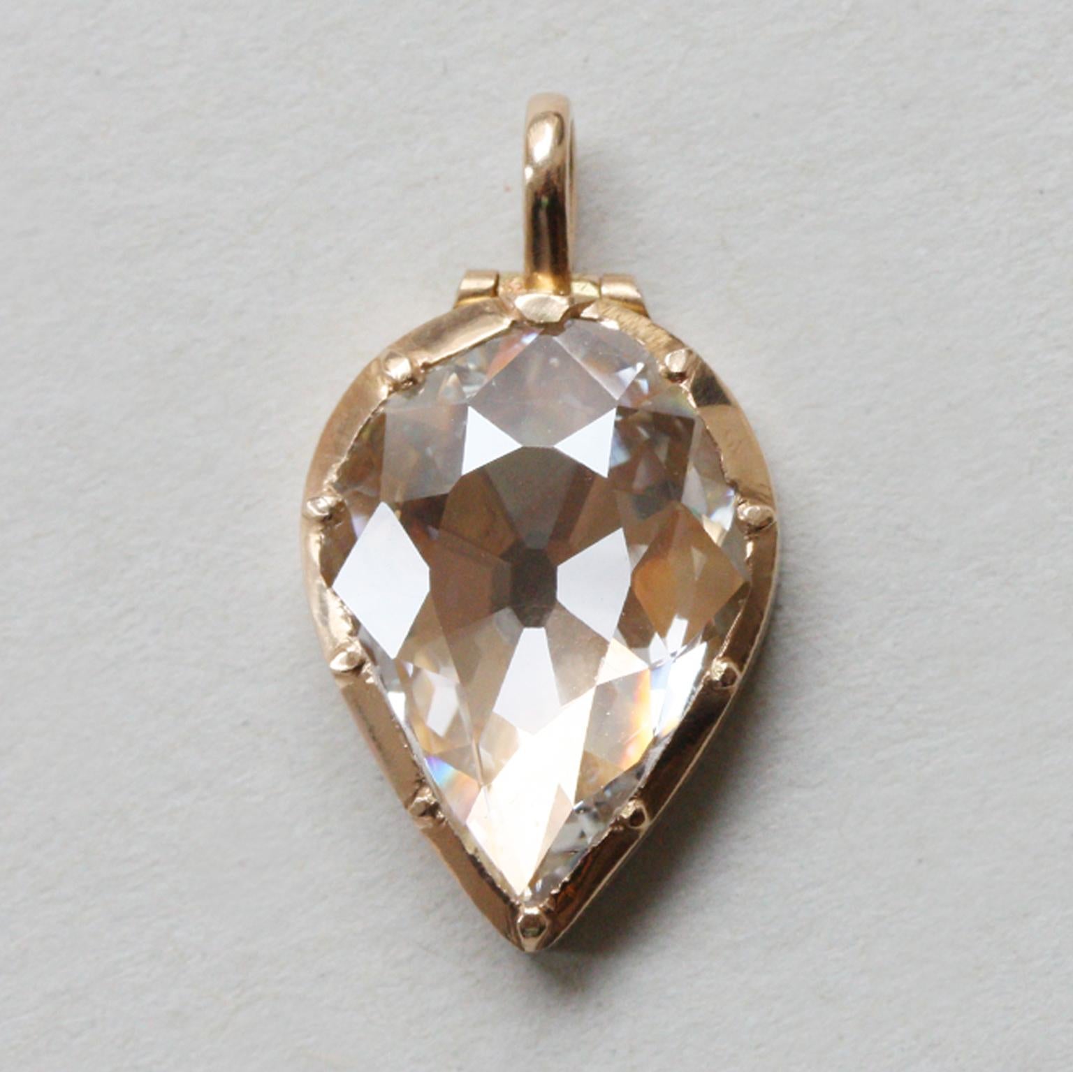 An 18 carat gold locket pendant set with a large and flat old cut pear shaped diamond (3.13 carat, J) in the lid of the locket which opens to reveal a small empty locket compartment where you can keep a tiny memento or miniature image, modern