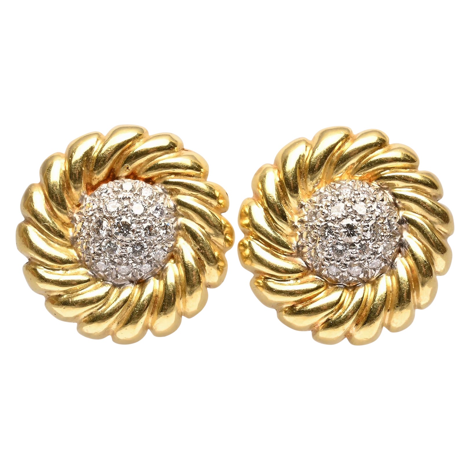 Eleganti orecchini in oro 18 carati con una spirale a coste che circonda un centro di diamanti. Ci sono 38 diamanti per un peso totale di 1,5 carati in una montatura a cupola.
I supporti a clip possono essere convertiti in pali.

