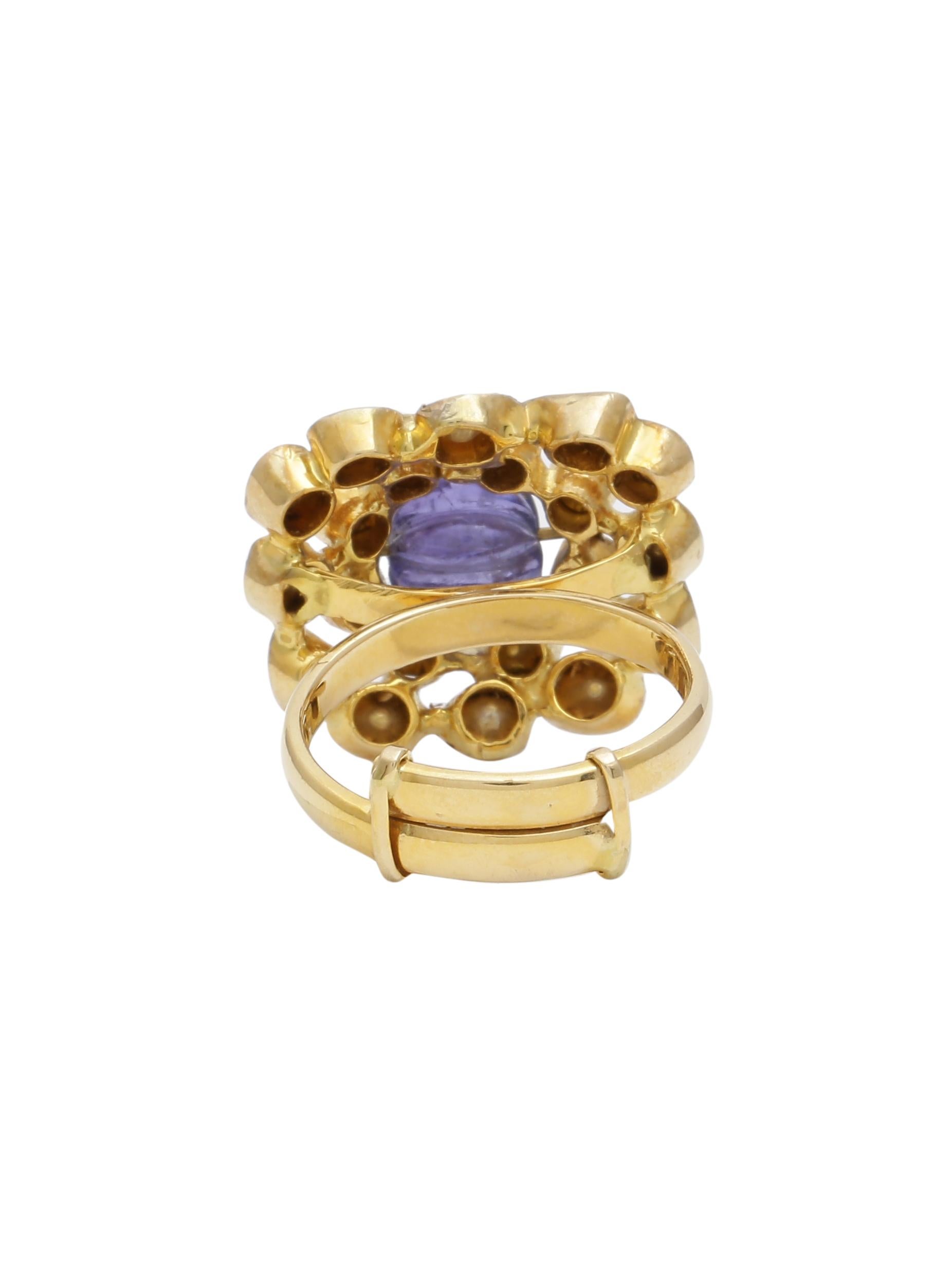 A beautiful cocktail ring with a carved Tanzanite Bead in the centre with uncut diamonds all around . The Beads is fixed with Gold wire in the ring. The ring size is adjustable with the special mechanism on the band. The ring is handmade in 18K