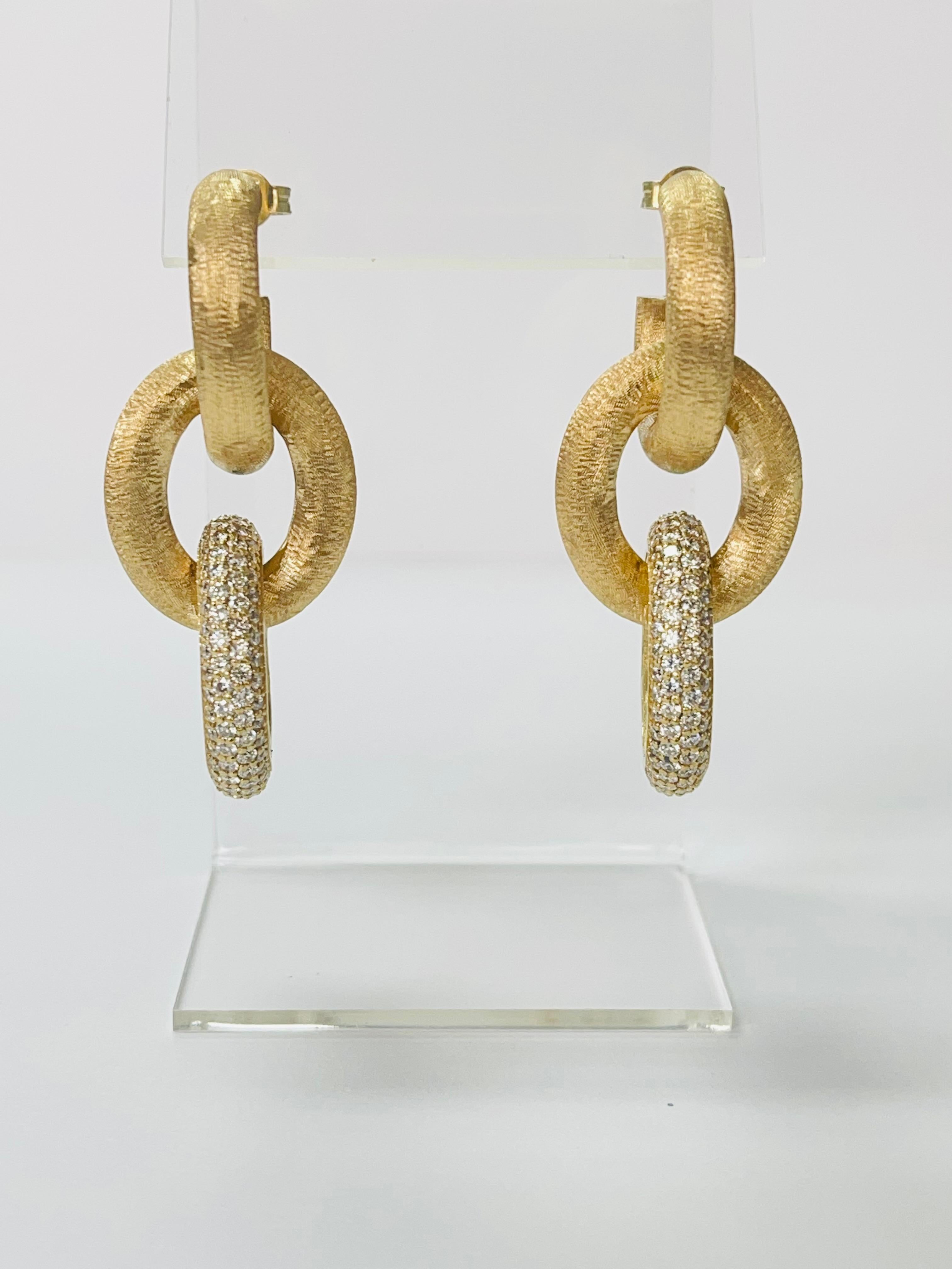 These exotic diamond and Italian 18k gold double hoop earrings are beautifully handmade. 
The details are as follows : 
Diamond weight : 4.61 Carats ( G color and VVS clarity ) 
Gold weight ; 31.71 grams 
Measurements : 2 inches long 

