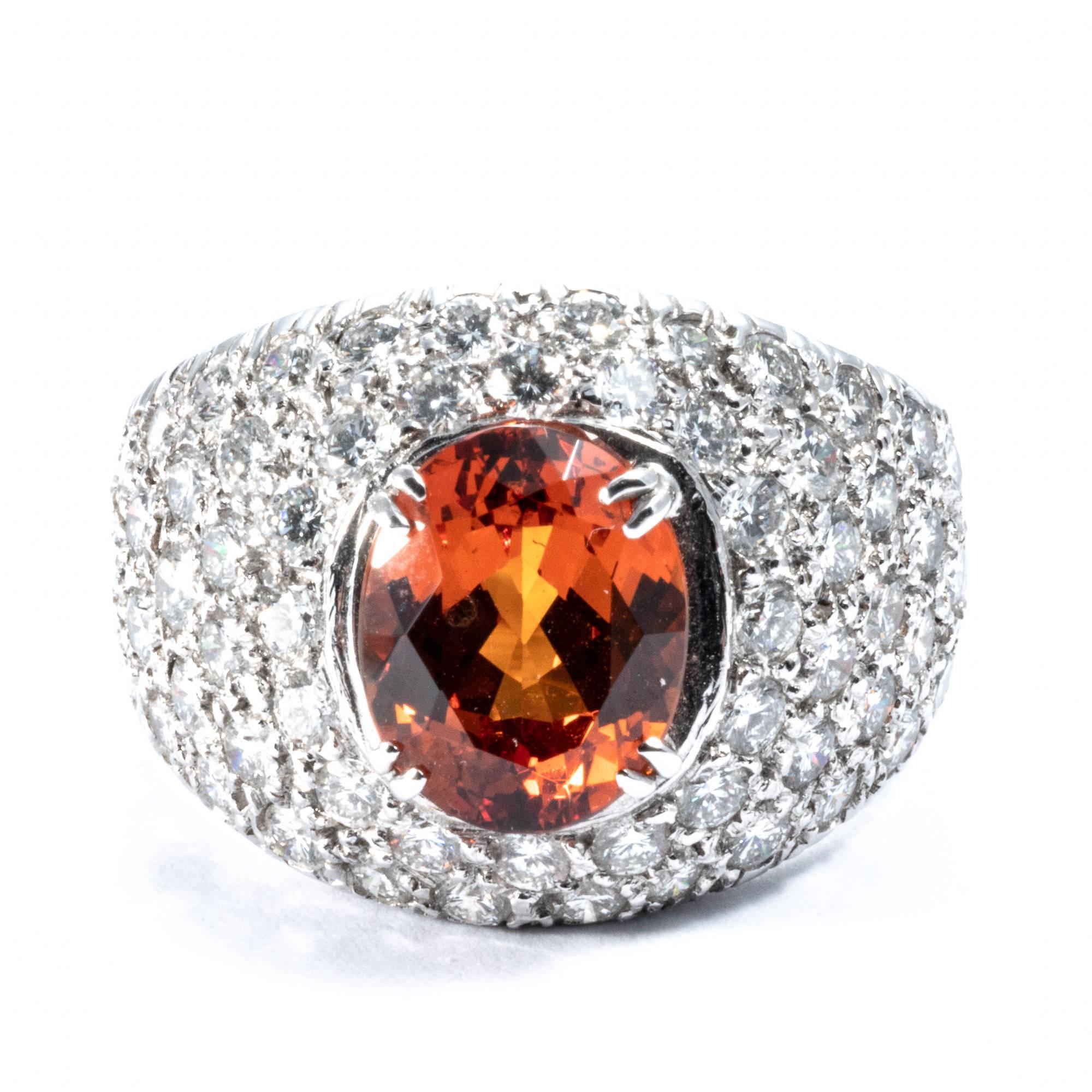 This wide ring band is accurately shaped.  Nice and  slender, this cocktail ring has will dress up your hand. Fully studded with 60 extra-white diamonds, it features a rare vivid mandarin garnet of 3.51 carats that will turn everybody's head. Also