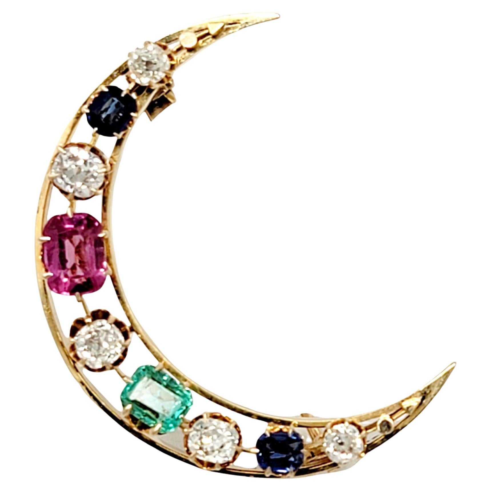 This gorgeous diamond and multi-gemstone moon brooch is simply out of this world! Bursting with glittering diamonds and sizeable colored gemstones, this celestial piece makes a stunning statement. The polished 18 karat yellow gold open crescent moon