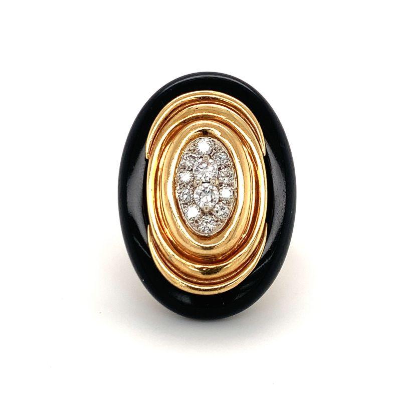 Diamond and black onyx ring in 18K yellow gold centering pave set, round brilliant cut diamonds totaling 0.75 ct. set within a fluted gold frame and oval onyx border. Signed and attributed to: Emis. Matched to EO.OK.4.

Glamorous, impressive,
