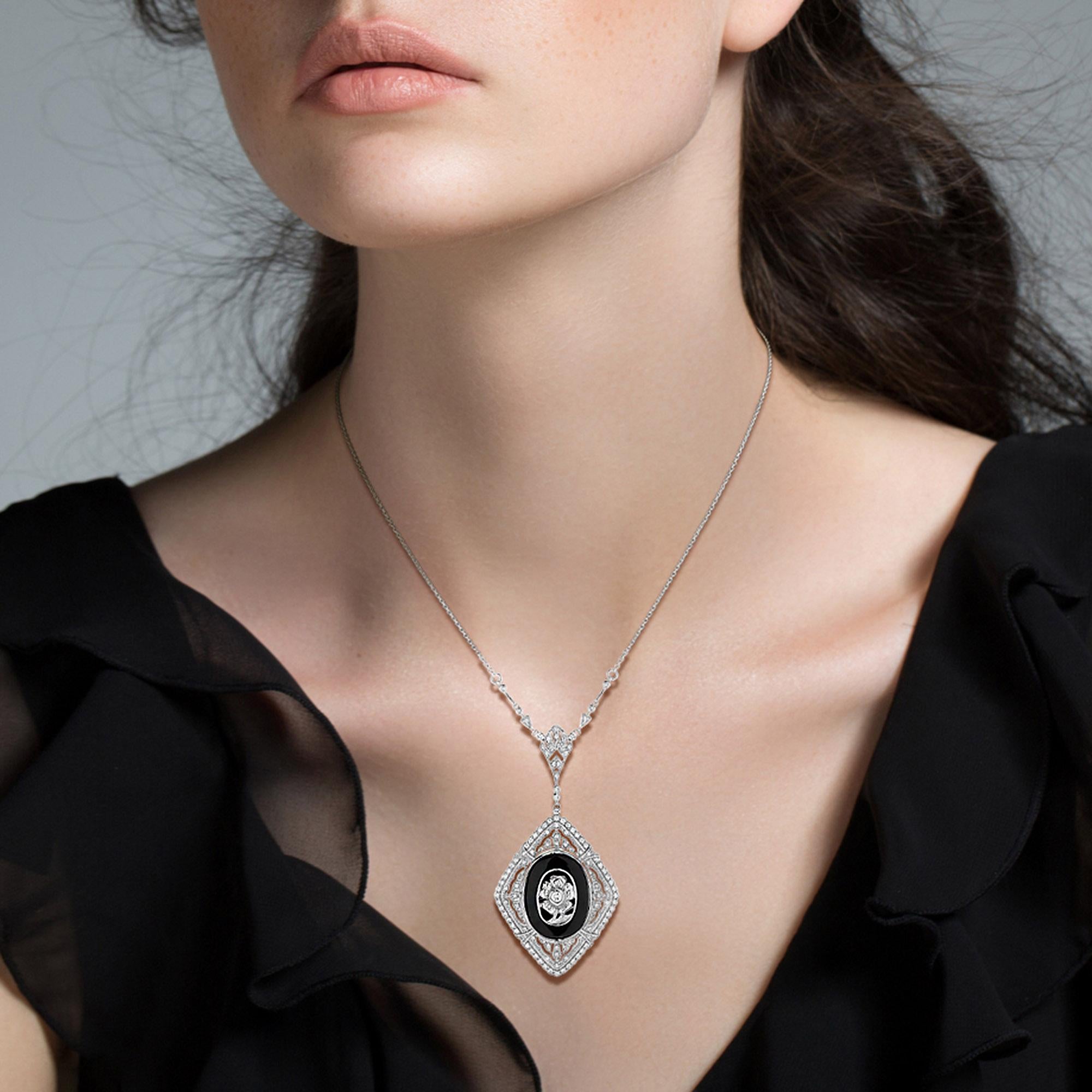 This dramatically striking Art-Deco style adornment brought to you in glorious black and white, centers on a glossy oval shape onyx overlaid with a diamond flower. These in turn are elegantly outline by open-work rows of glittering round diamonds