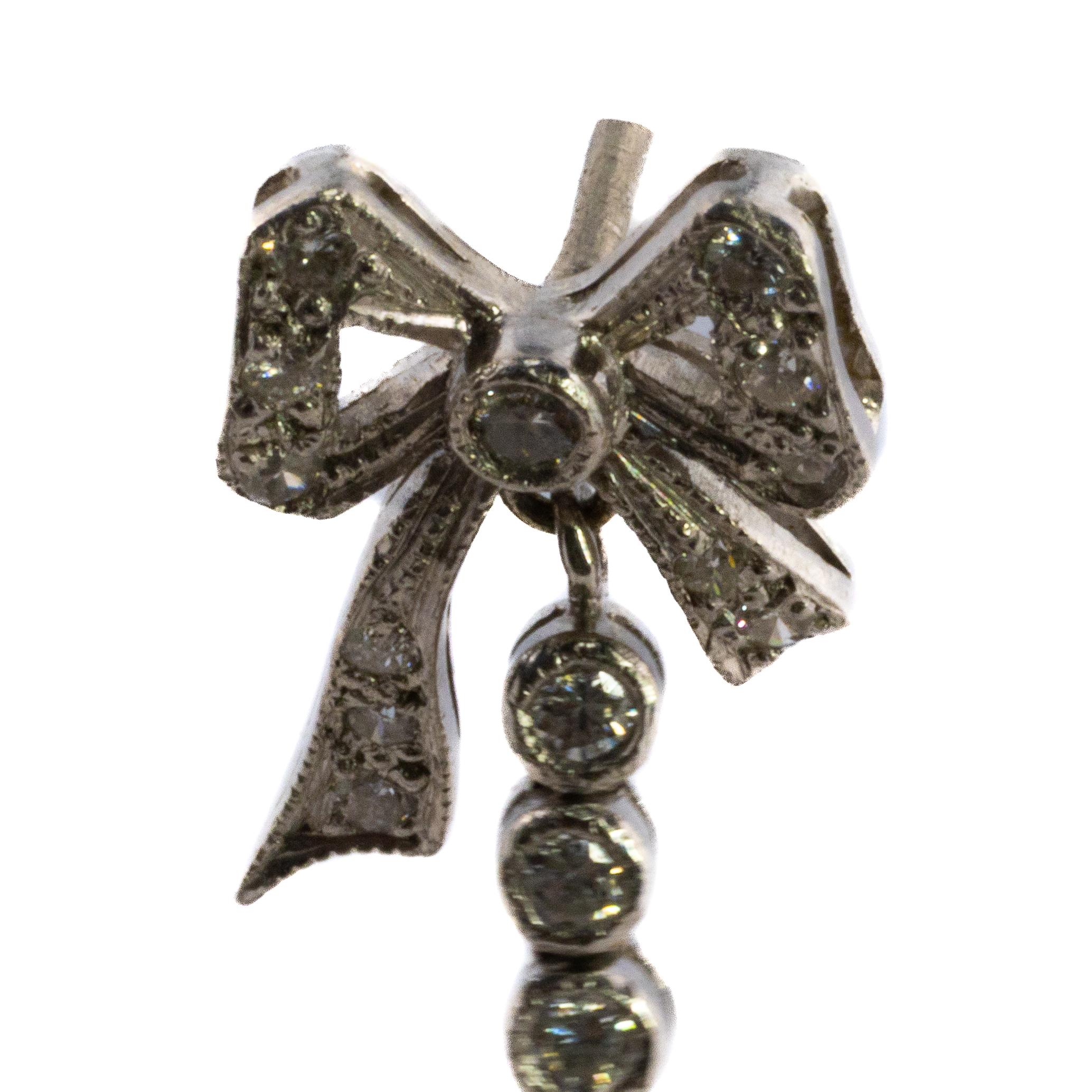 Diamond and Onyx Bow Drop Earrings

Description:
A refined pair of earrings featuring a charming bow motif set with sparkling diamonds, suspending a line of bezel-set diamonds that lead to faceted onyx drops. The contrast between the glittering