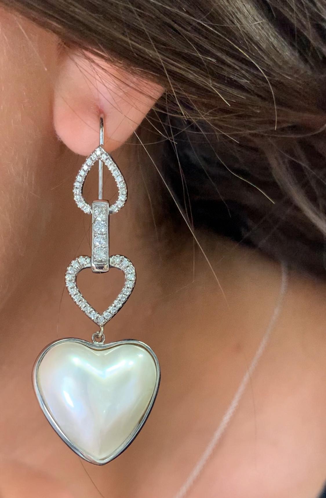 Discover the allure of these elegant classic diamond and pearl at deco drop earrings, designed to add a touch of sophistication to any outfit. The timeless Pearl gemstones in a beautiful heart shape catch the light beautifully, making them perfect