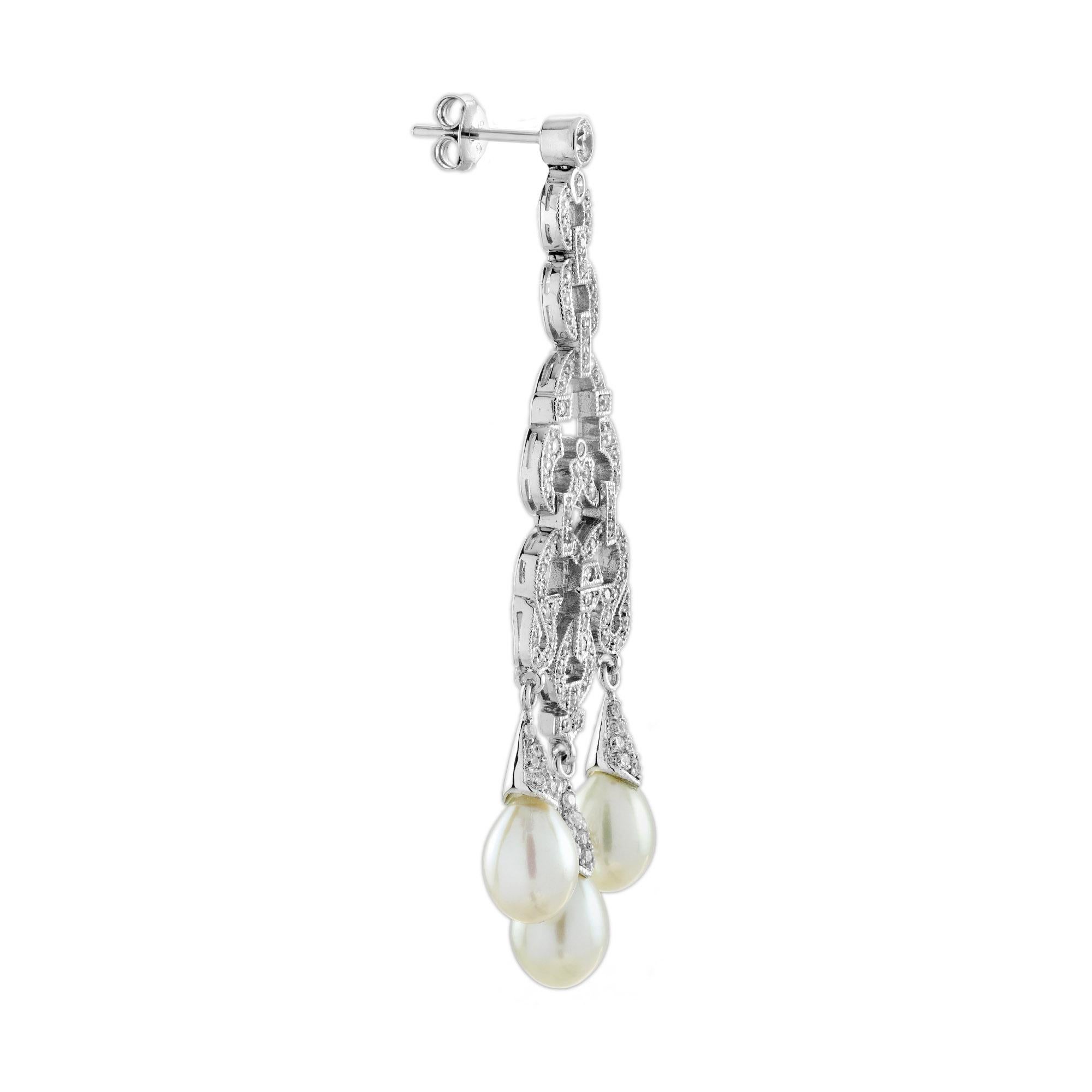 Una lussuosa combinazione di diamanti scintillanti e perle lucenti. Il design geometrico degli orecchini cattura l'essenza dell'Art Déco, con diamanti che accentuano l'elegante movimento delle perle. Lo stile penzolante aggiunge un tocco di