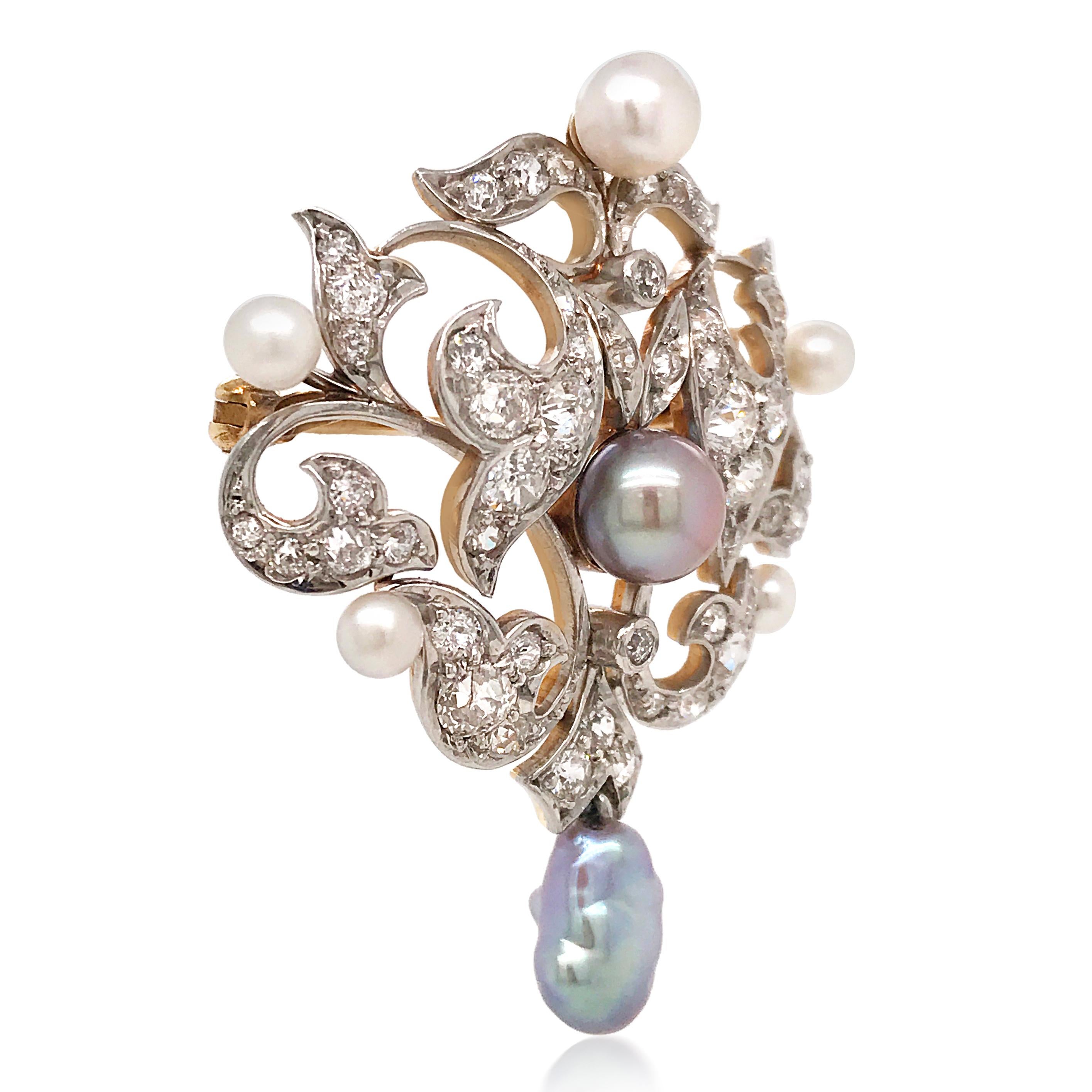 This alluring Victorian pin brooch of opulent aesthetic is crafted in gold-topped platinum, centered with a lustrous gray pearl, measuring 7.12mm in diameter. It is also adorned with 5 white pearls on top and sides of the brooch, measuring from