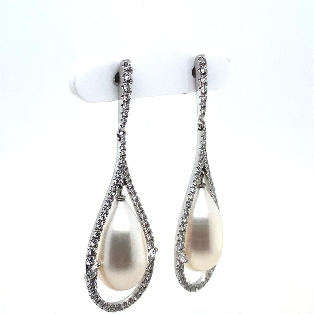 A pair of diamond and pearl drop earrings in 18 karat white gold.

Each classic and contemporary earring is designed with a pear shaped cultured pearl suspended from a row of individually set diamonds leading to a fine frame claw set with round