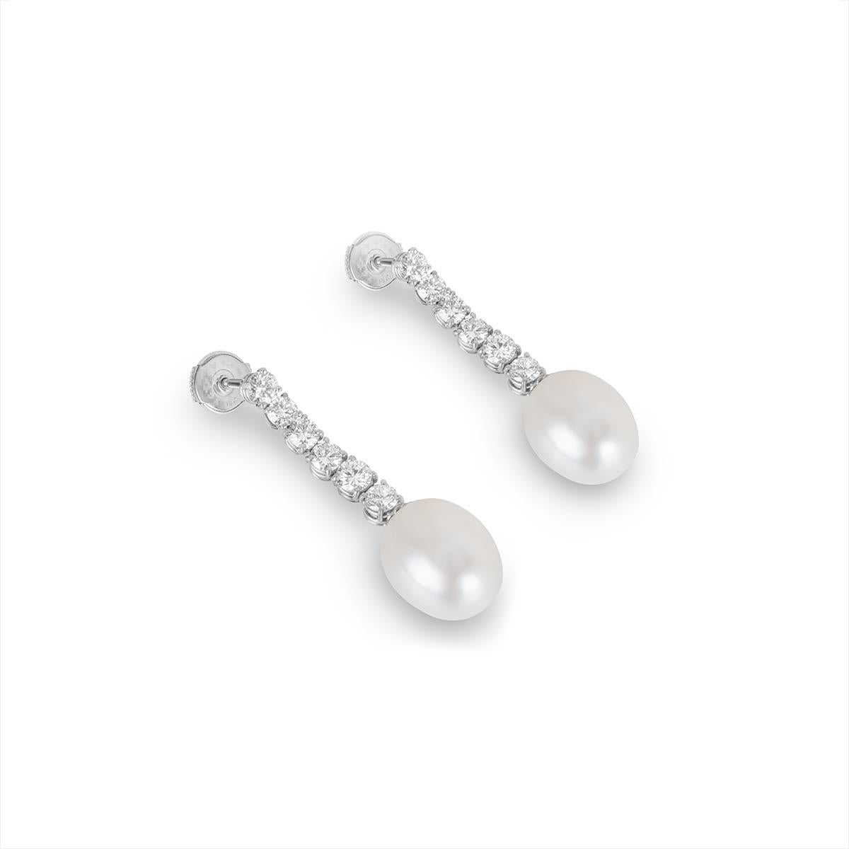 A luxurious pair of 18k white gold diamond and pearl drop earrings. The earrings feature 6 round brilliant cut diamonds set vertically, totalling approximately 1.90ct, predominantly G-F colour and VS2 clarity. Complementing the diamonds are two