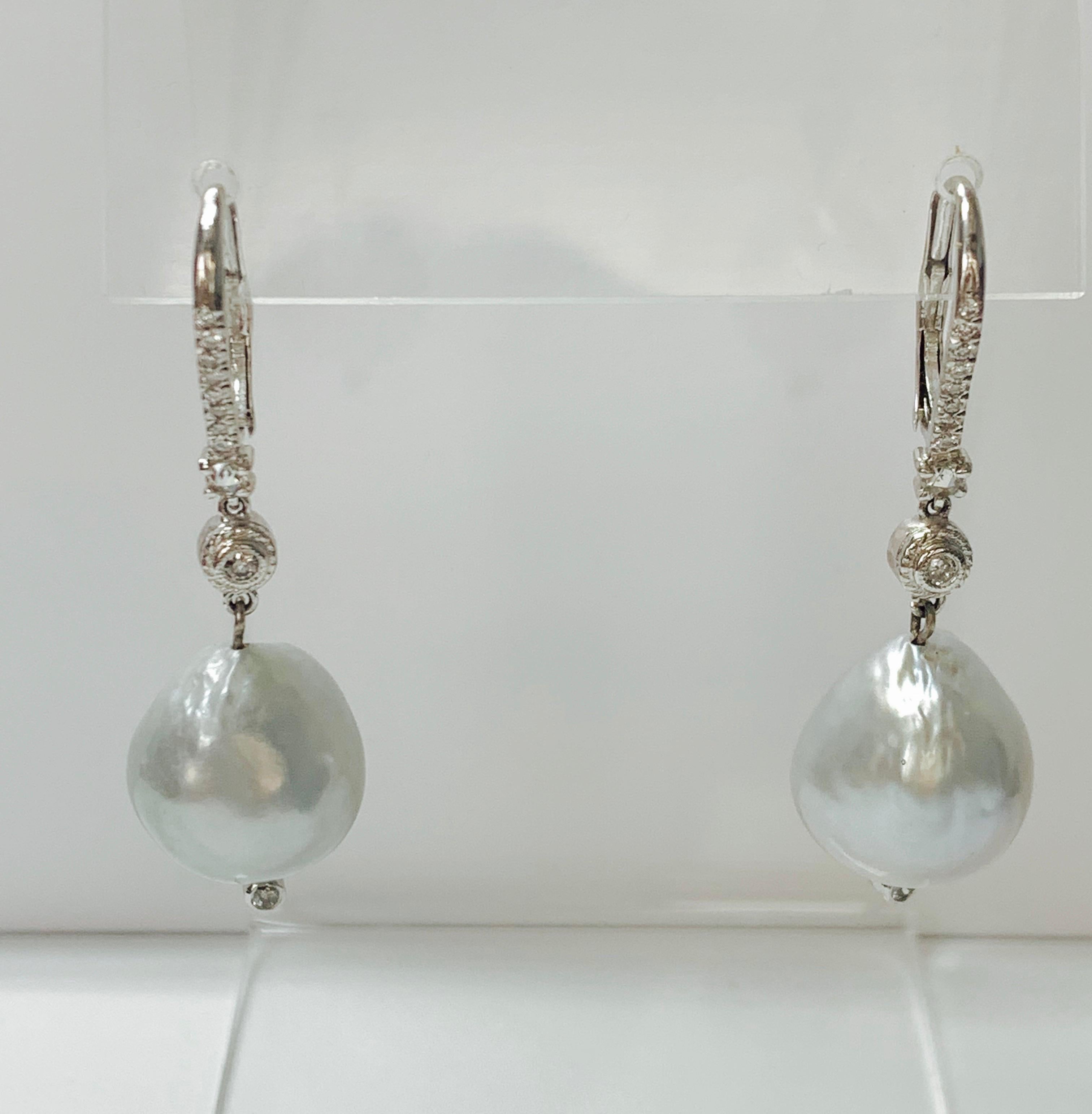 Diamond and pearl drop earrings handcrafted in 18k white gold. 
The details are as follows : 
Diamond weight: 0.50 carat ( I color and SI 1 clarity ) 
Pearl: 14.7mm by 13.5mm each 
Measurements: 1 3/4 inches long 
Metal : 18k white gold 


